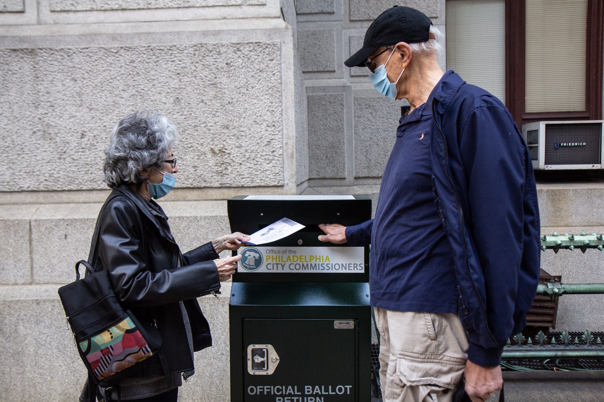 Alice and Len Sayles, Rittenhouse Square residents, return their ballots in the drop box outside City Hall in Philadelphia.