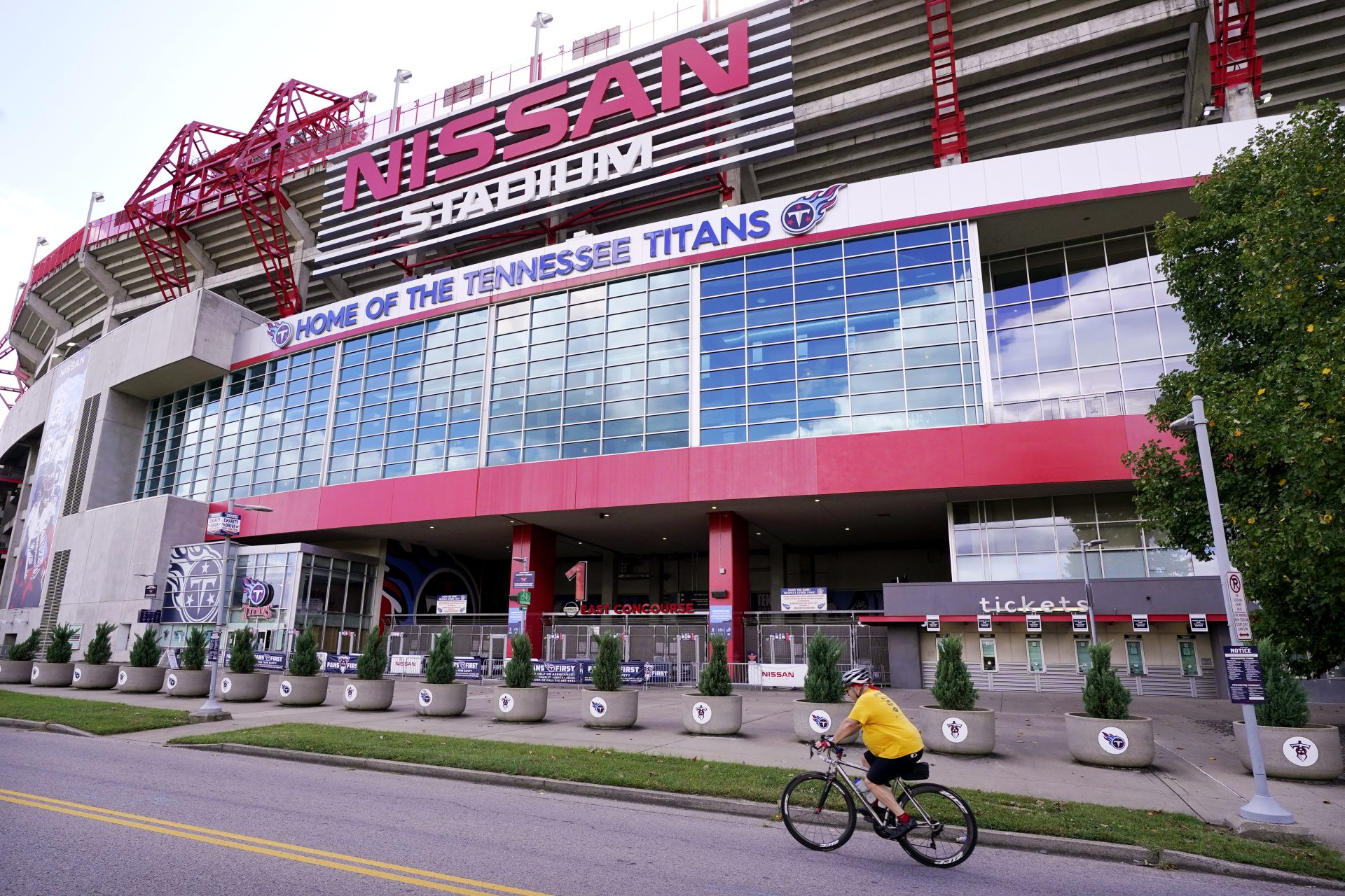 A cyclist passes by Nissan Stadium, home of the Tennessee Titans, Tuesday, Sept. 29, 2020, in Nashville, Tenn. The Titans suspended in-person activities through Friday after the NFL says three Titans players and five personnel tested positive for the coronavirus, becoming the first COVID-19 outbreak of the NFL season in Week 4.