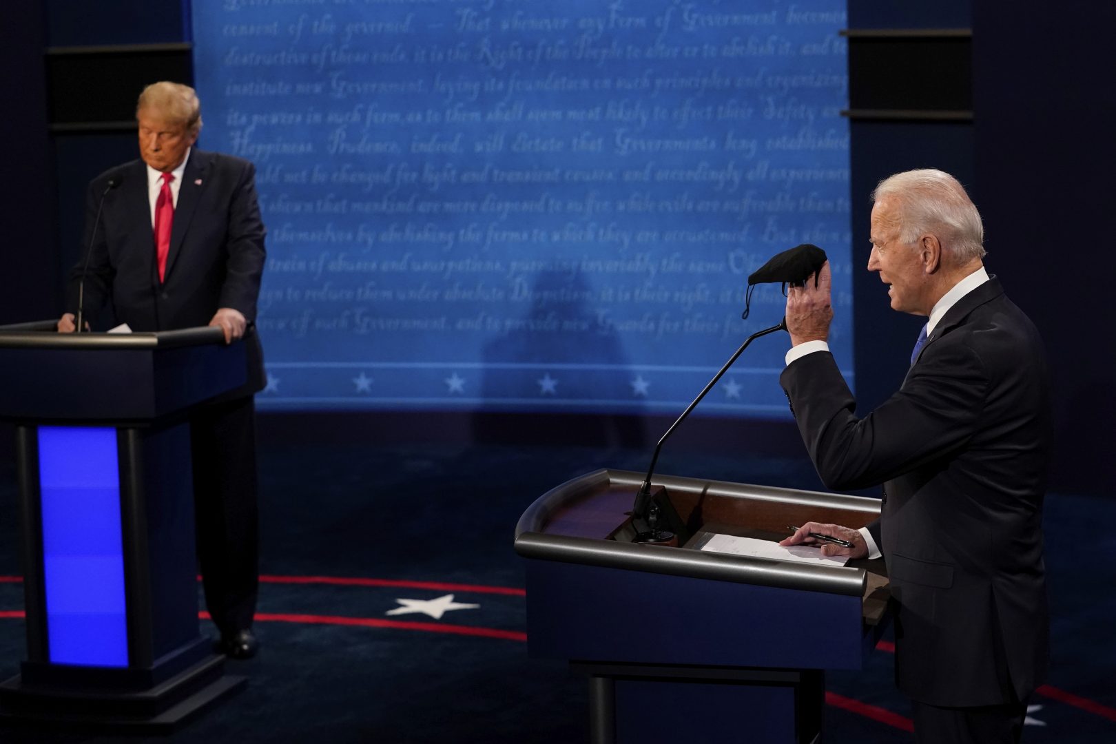 Democratic presidential candidate former Vice President Joe Biden holds up a mask as President Donald Trump takes notes during the second and final presidential debate Thursday, Oct. 22, 2020, at Belmont University in Nashville, Tenn. 