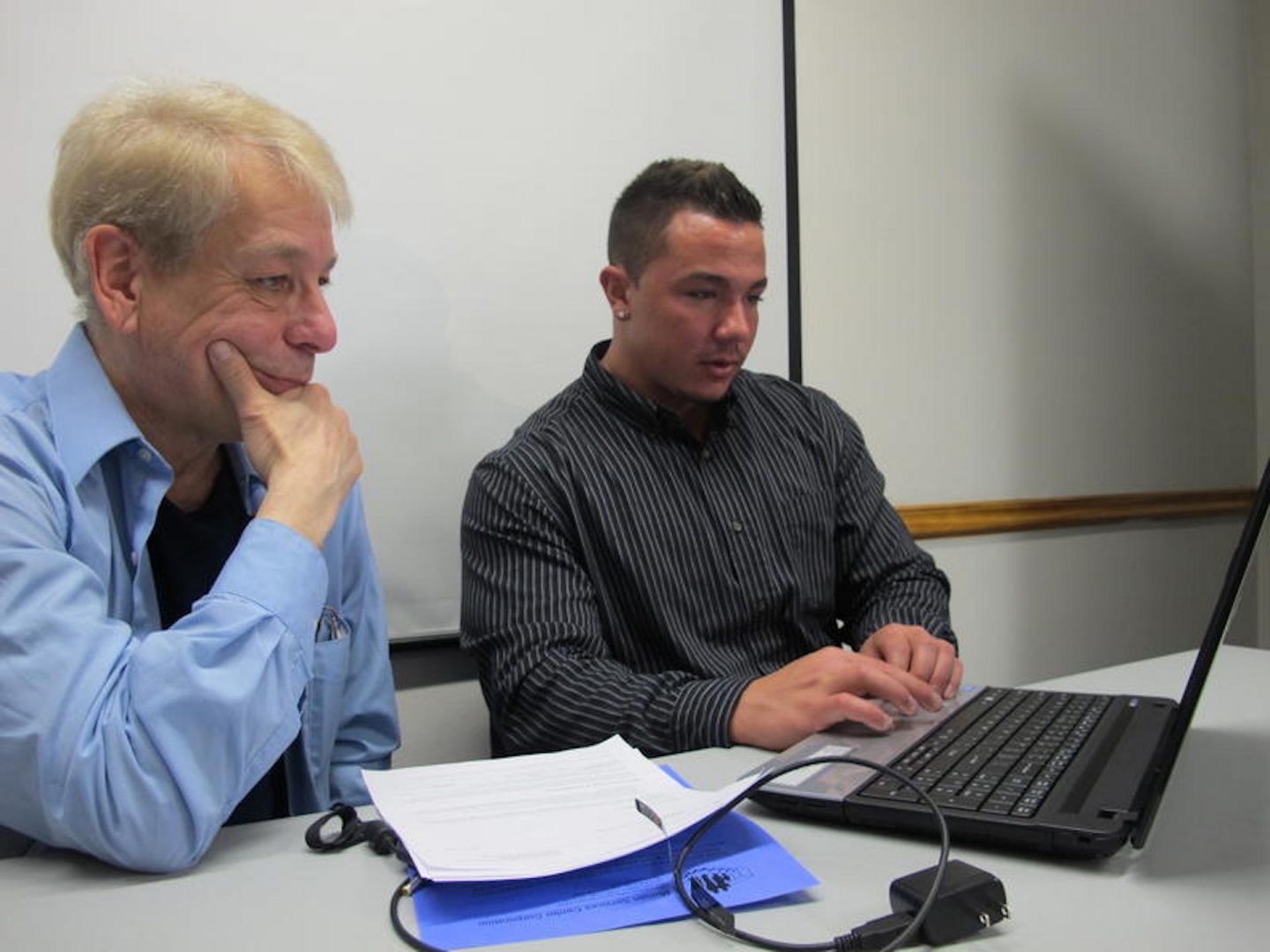 FILE PHOTO: Ronald Pederson (left) gets help getting health insurance from navigator Christian Fattore.
