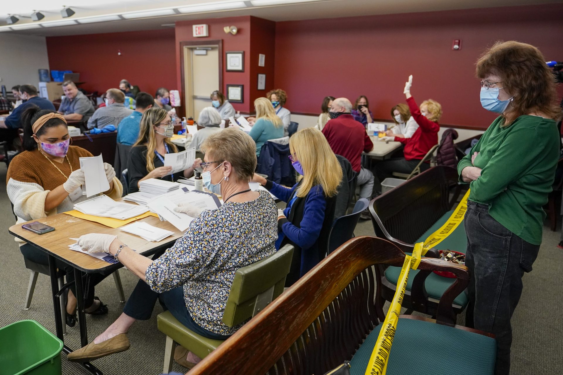 Lynn Muchler-Stash, right, an observer with the Democratic Party of Pennsylvania watches as municipal workers sort and count Luzerne County ballots, Wednesday, Nov. 4, 2020, in Wilkes-Barre, Pa.