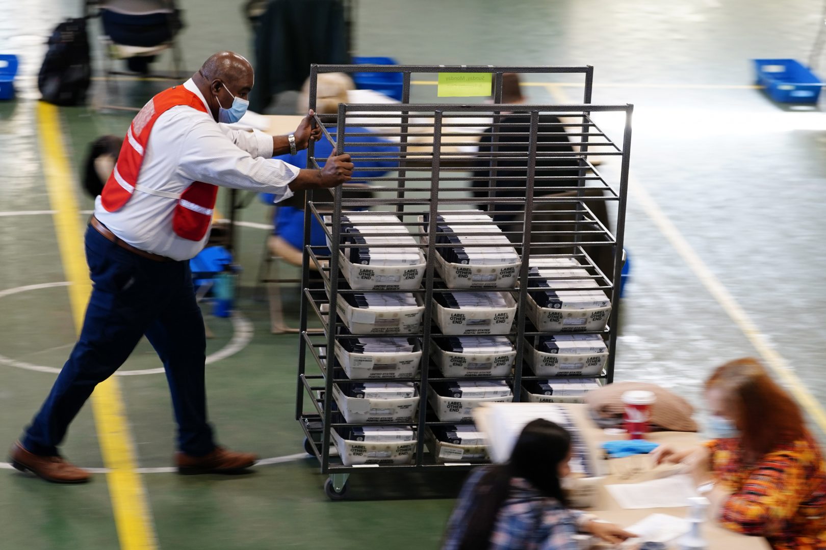 James Lyles, a Chester County election worker, pushes mail-in and absentee ballots for the 2020 general election in the United States to be processed at West Chester University, Wednesday, Nov. 4, 2020, in West Chester, Pa. 