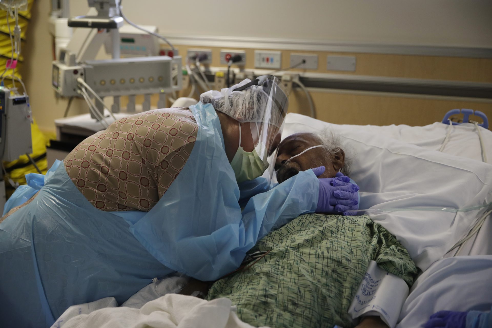 FILE PHOTO: In this July 31, 2020, file photo, Romelia Navarro, 64, weeps while hugging her husband, Antonio, in his final moments in a COVID-19 unit at St. Jude Medical Center in Fullerton, Calif. In November 2020, California reached an unwelcome coronavirus record: its 1 millionth positive test.