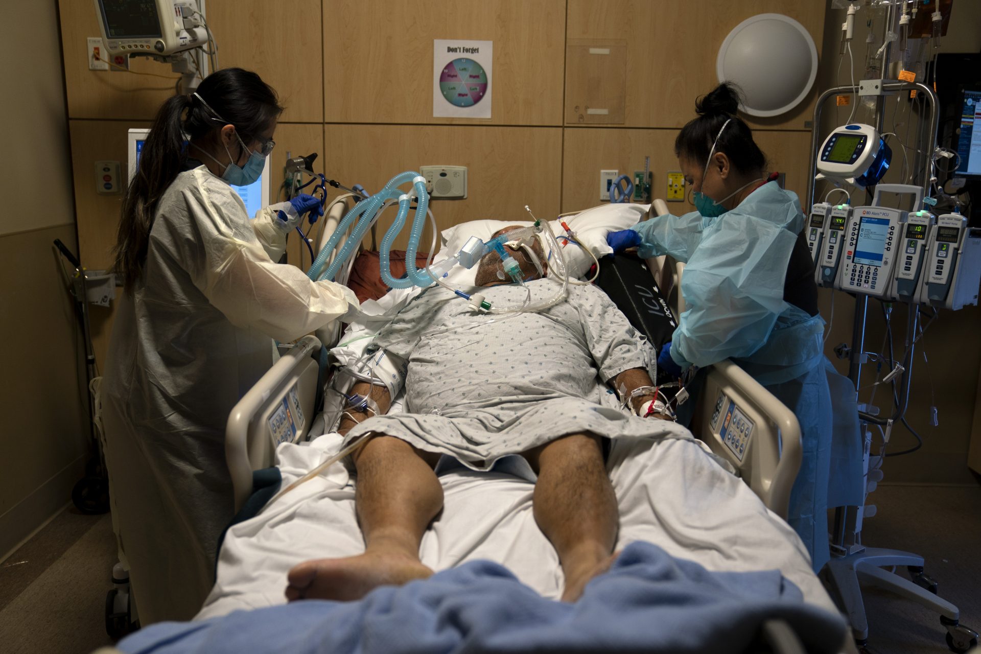 Registered nurses Karen Ross, right, and Angela Nguyen assist a COVID-19 patient at Providence Holy Cross Medical Center in the Mission Hills section of Los Angeles, Thursday, Nov. 19, 2020. 