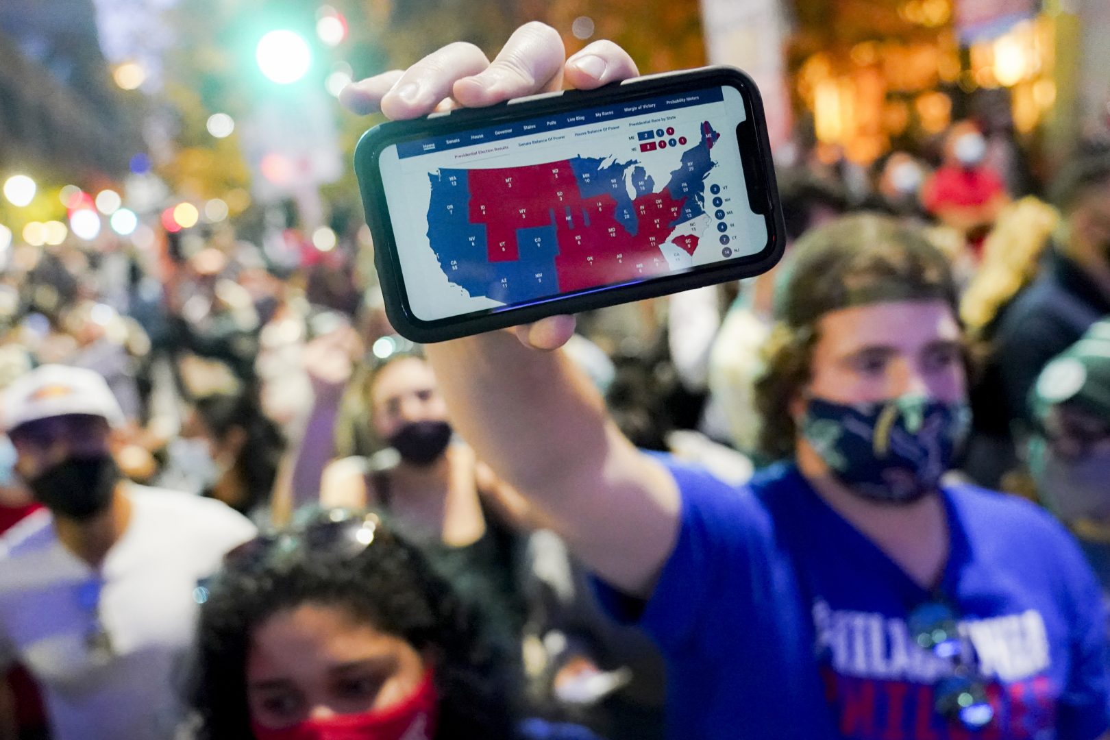 A supporter of President-elect Joe Biden holds up a phone displaying the Electoral College map in Philadelphia on Nov. 7.