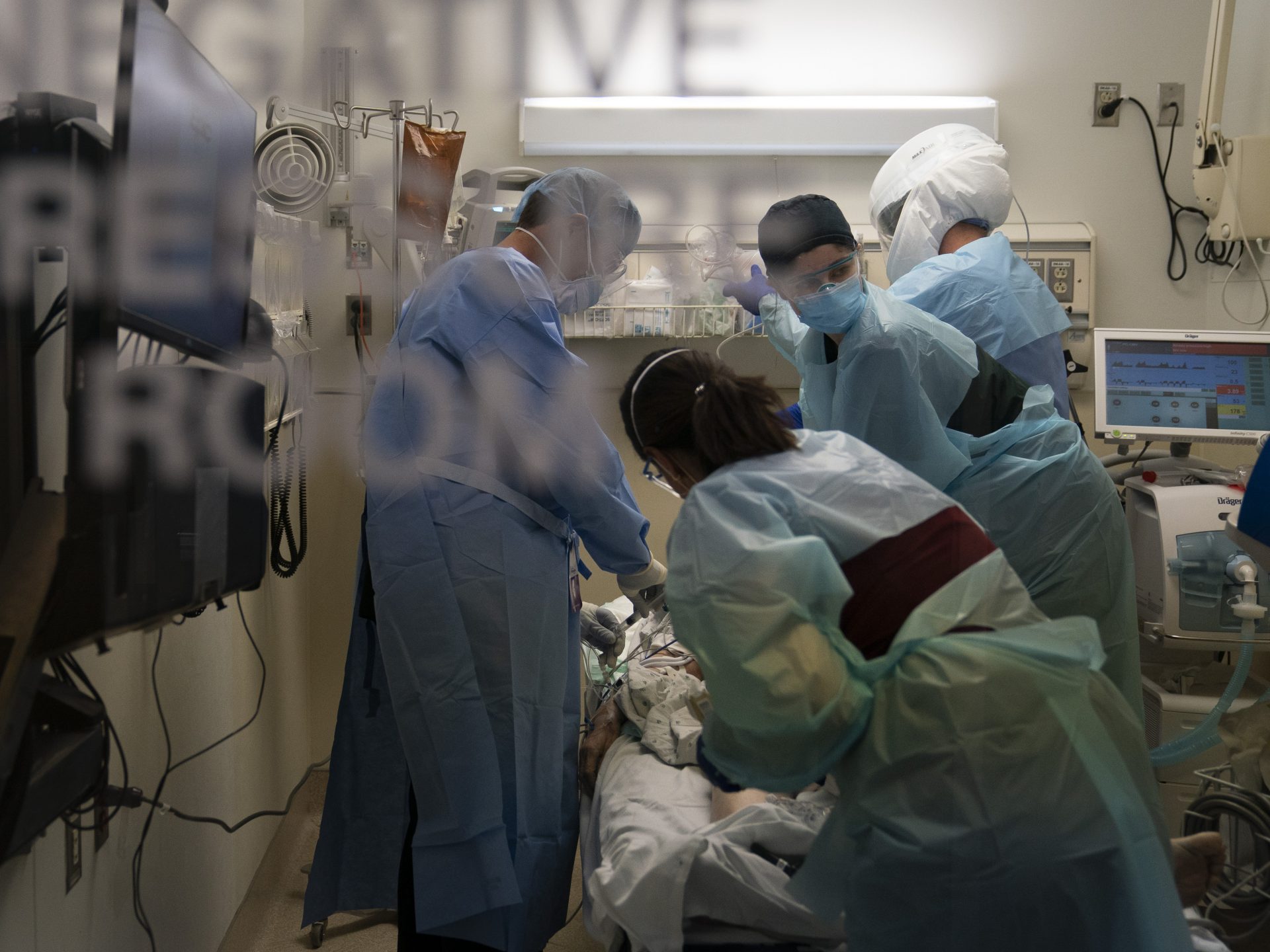 EMT Giselle Dorgalli, second from right, looks at a monitor while performing chest compression on a patient who tested positive for coronavirus in the emergency room at Providence Holy Cross Medical Center in the Mission Hills section of Los Angeles, Thursday, Nov. 19, 2020. California is imposing an overnight curfew on most residents as the most populous state tries to head off a surge in coronavirus cases that it fears could tax its health care system, Gov. Gavin Newsom announced Thursday.