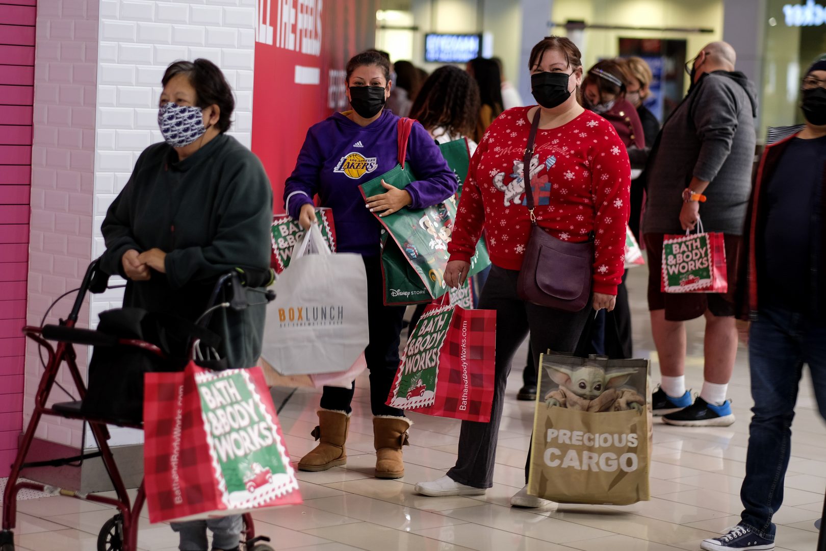 Black Friday shoppers wearing face masks wait in line to enter a store at the Glendale Galleria in Glendale, Calif., Friday, Nov. 27, 2020. 