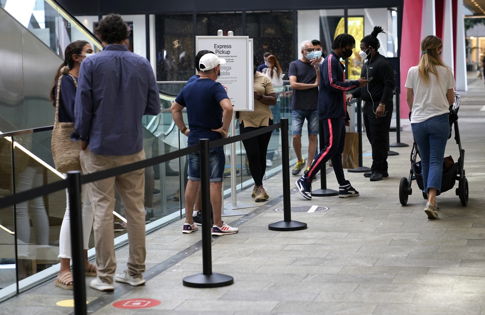 Customers wait in line at Express Pickup outside of an Apple store at Brickell City Centre, Friday, Nov. 6, 2020, in Miami. After months of slumping sales and businesses toppling into bankruptcy, Black Friday is offering a small beacon of hope. In normal times, Black Friday is the busiest shopping day of the year, drawing millions of shoppers eager to get started on their holiday spending. But these are not normal times.