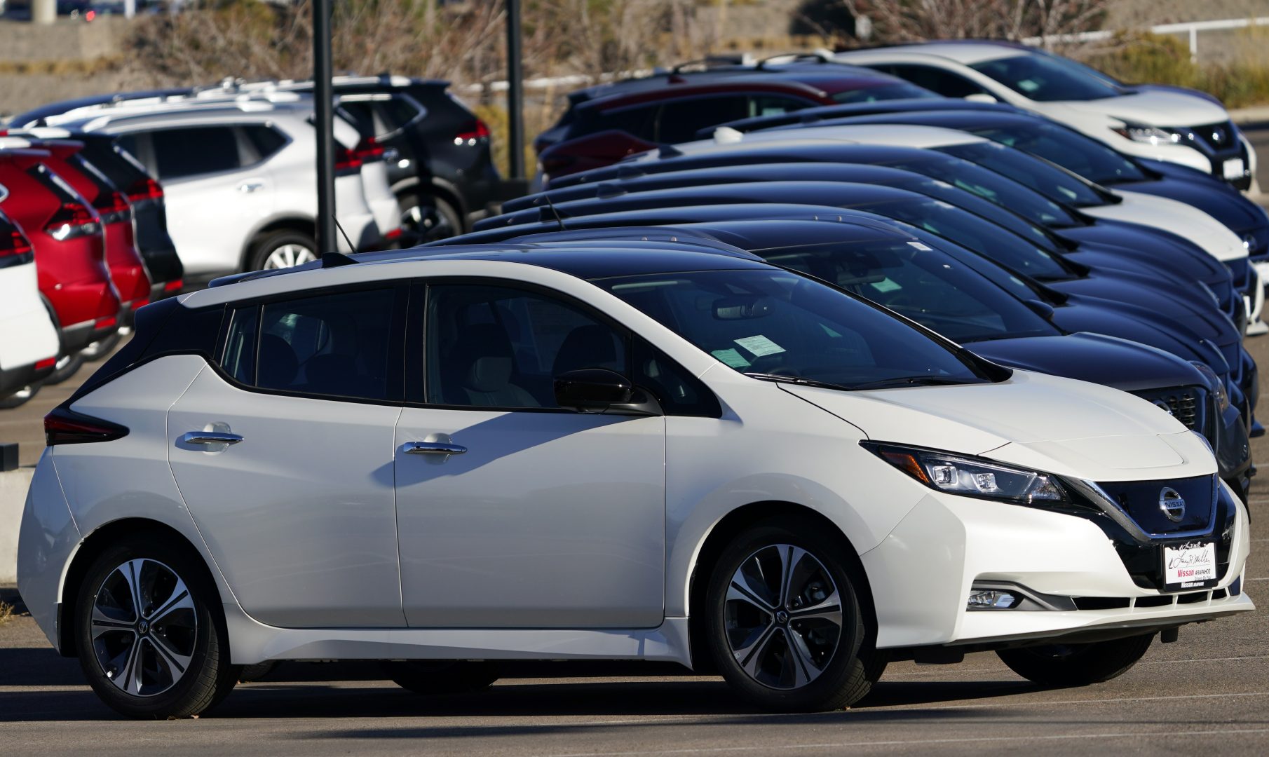 A long line of unsold 2021 Leaf electric vehicles sits at a Nissan dealership Sunday, Nov. 8, 2020, in Highlands Ranch, Colo. 