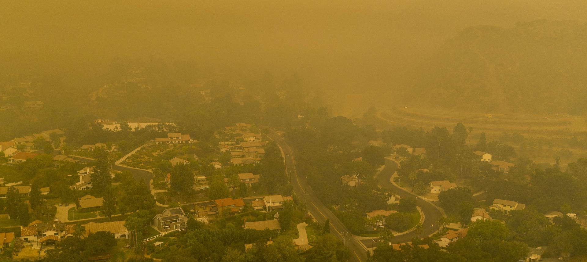 Climate change has been a key factor in increasing the risk and extent of wildfires and other catastrophic weather events. An aerial view shows neighborhoods shrouded in smoke from the Bobcat Fire in California in September.