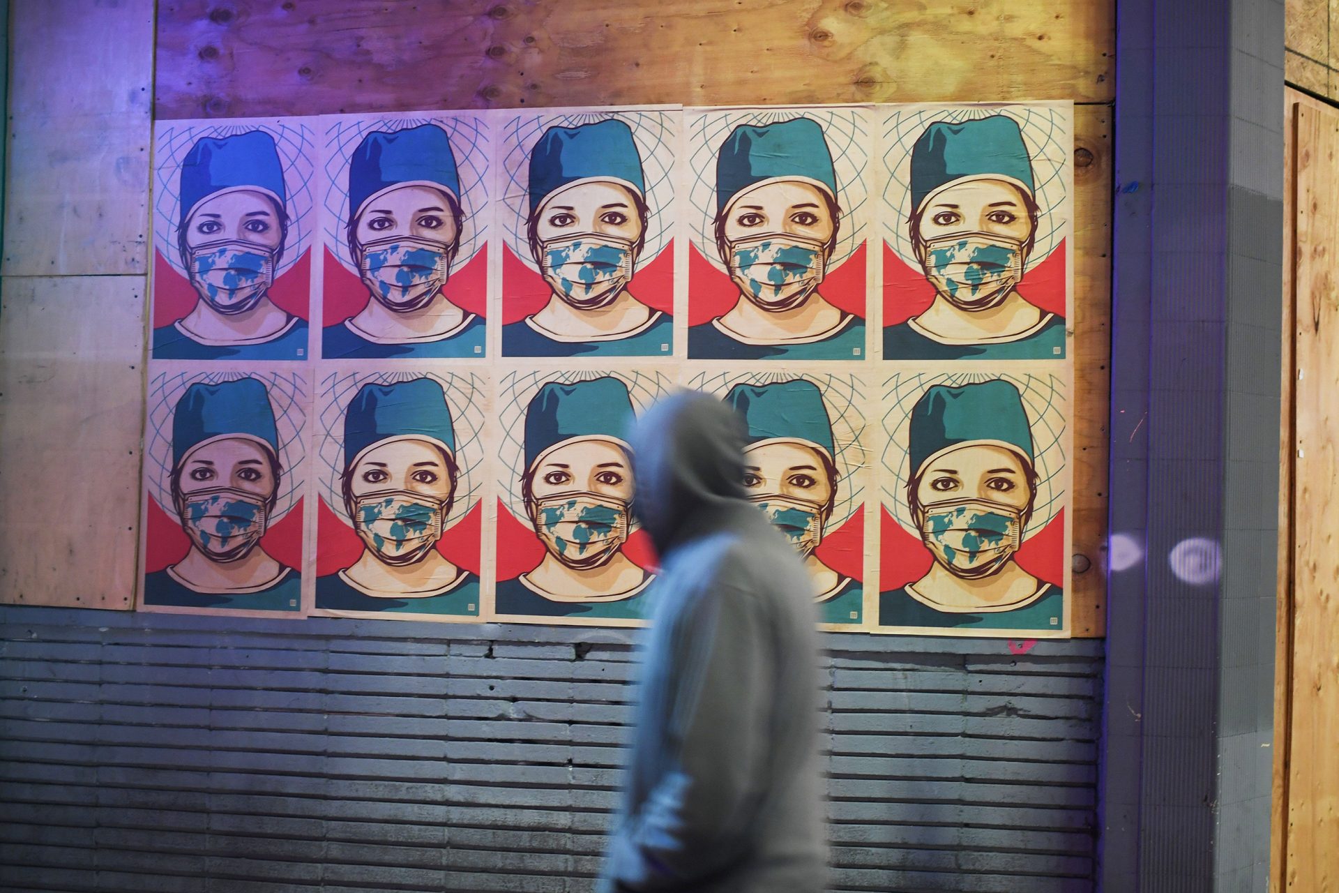 A pedestrian walks past posters showing a health care worker wearing a mask in Los Angeles as California became the second state to surpass 1 million coronavirus infections last week.