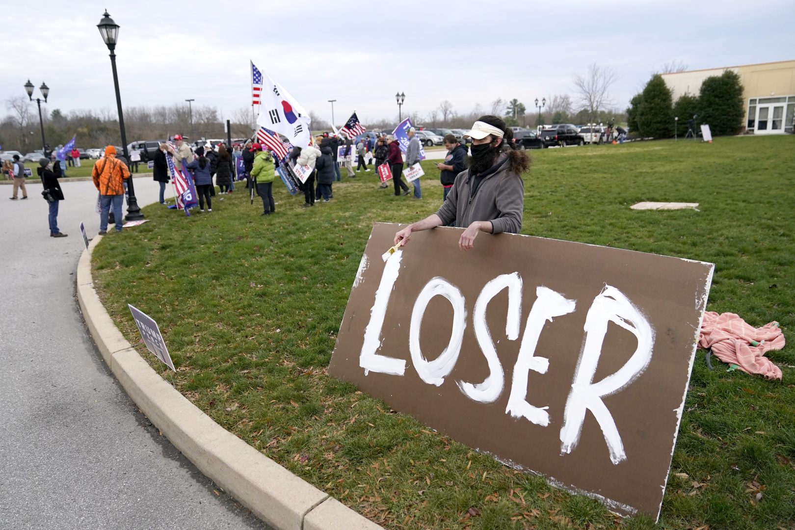 Supporters of President Donald Trump, left, gather as a counter protester holds a sign outside of the Wyndham Hotel where the Pennsylvania State Senate Majority Policy Committee is scheduled to meet, Wednesday, Nov. 25, 2020, in Gettysburg, Pa.