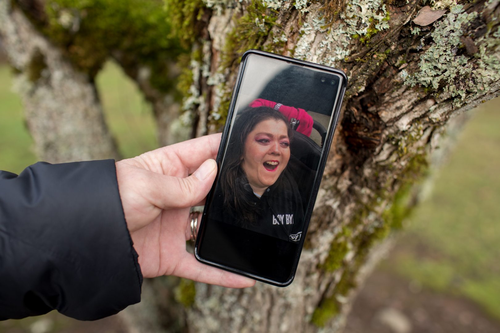 Kimberly Conger holds a phone photo of Sarah McSweeney in Oregon City, Oregon on Tuesday, November 24, 2020. McSweeney's bright pink makeup was a common look for her outgoing personality and love of color. 