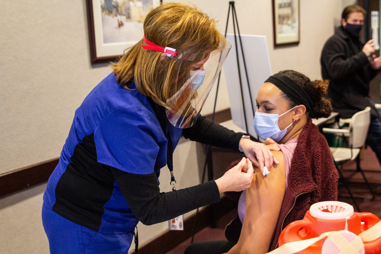 Allison Brown, Union Mills Chadds Ford School District nurse, receives the Moderna COVID-19 vaccine from RN Penny Caracas.