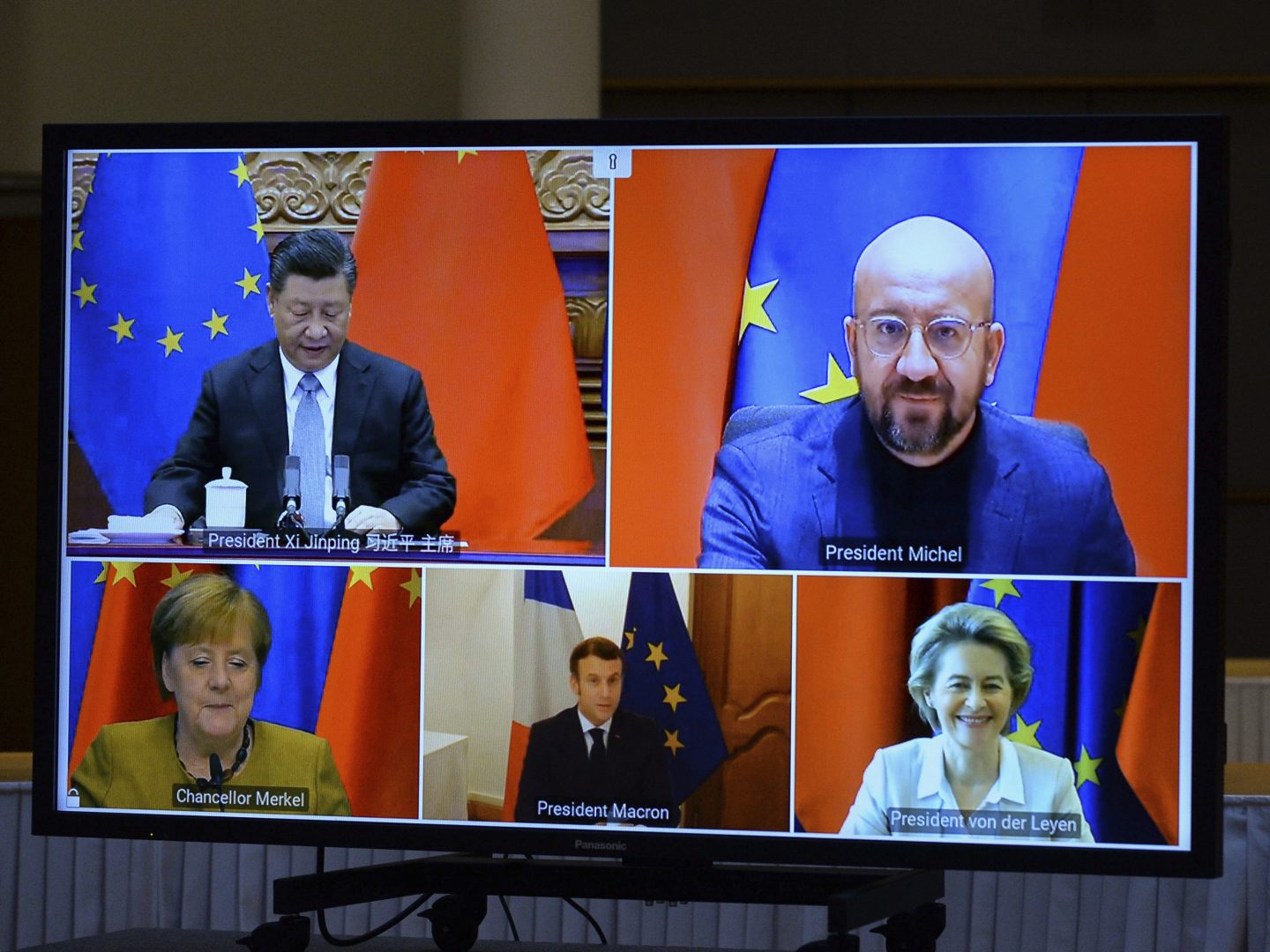 A screen displays live Chinese President Xi Jinping, top left, European Council President Charles Michel, top right, European Commission President Ursula von der Leyen, bottom right, French President Emmanuel Macron, bottom center, and German Chancellor Angela Merkel during an EU-China Leaders' meeting video conference at the European Council headquarters in Brussels, Wednesday, Dec. 30, 2020. The European Union top officials and China president Xi Jinping will conclude Wednesday a business investment deal that will open big opportunities to European companies, with the potential to irk the new American administration. (Johanna Geron, Pool Photo via AP)