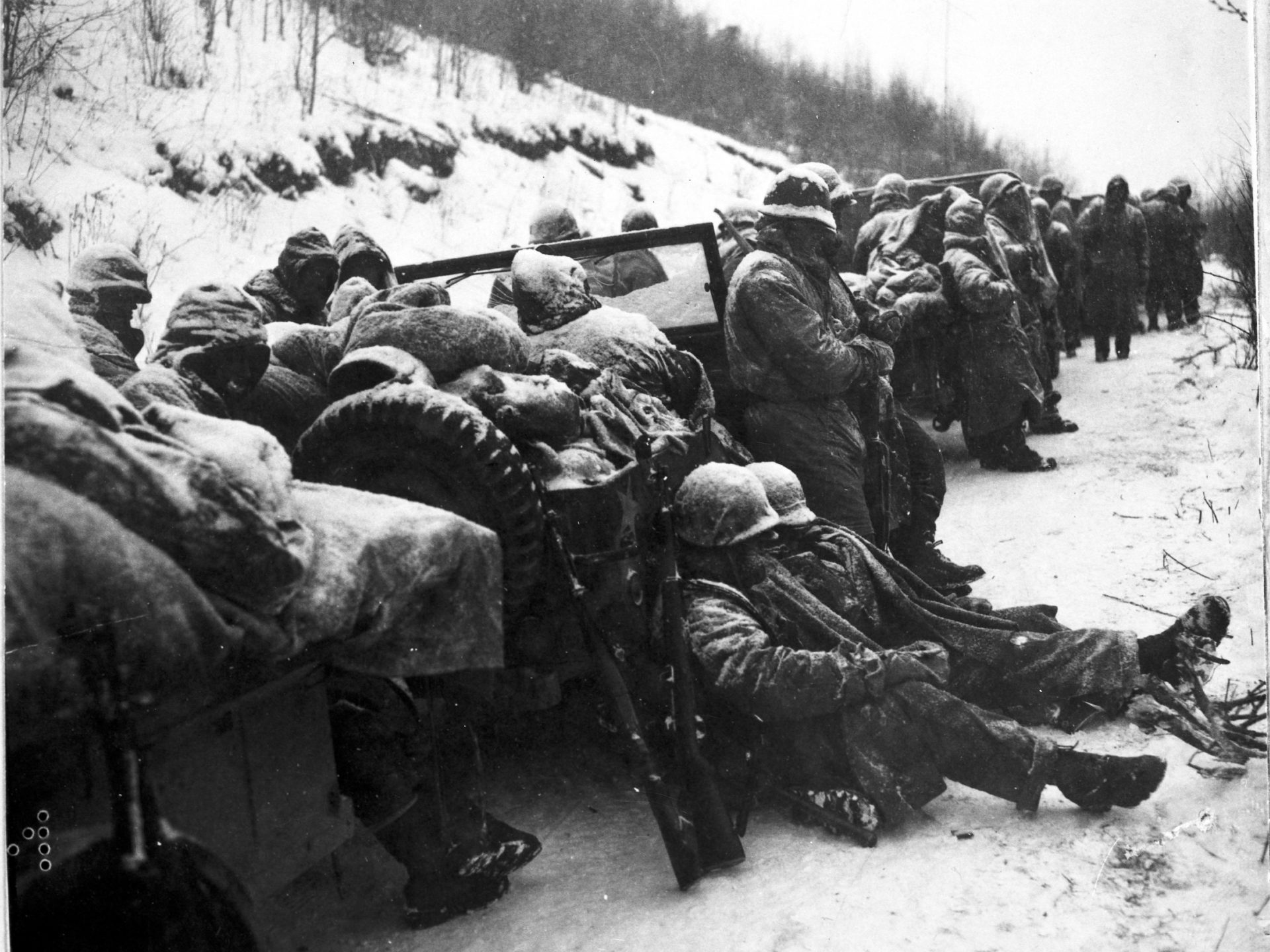 Marines of the 5th and 7th regiments who hurled back a surprise onslaught by three Chinese communist divisions wait to withdraw from the Chosin Reservoir area circa December 1950.