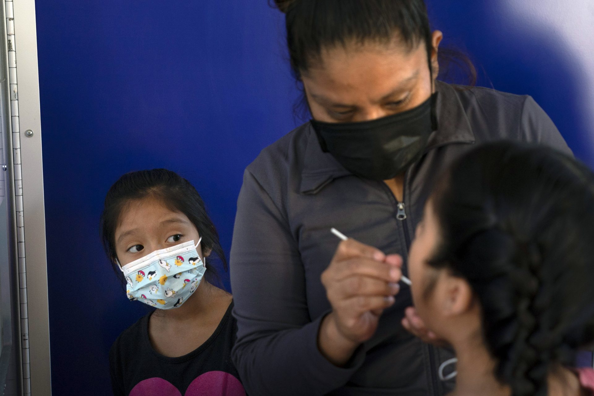 In this Dec. 9, 2020, file photo, Katie Ramirez, left, watches as her mother, Claudia Campos, swabs the mouth of her daughter, Hailey, for a COVID-19 test at a testing site in Los Angeles. As officials met to discuss approval of a COVID-19 vaccine on Thursday, Dec. 10, the number of coronavirus deaths has grown bleaker than ever.