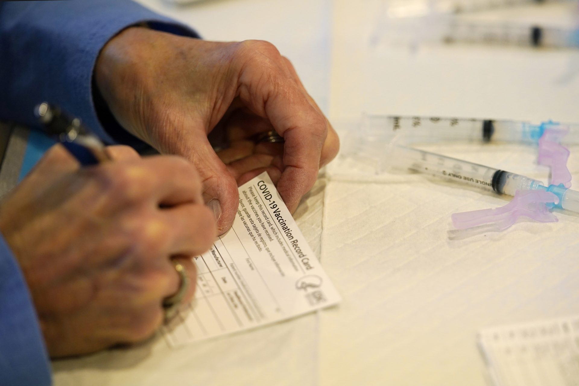 Pat Moore, with the Chester County, Pa., Health Department, fills out a vaccination record card before administering the Moderna COVID-19 vaccine to emergency medical workers and healthcare personnel at the Chester County Government Services Center, Tuesday, Dec. 29, 2020, in West Chester, Pa.