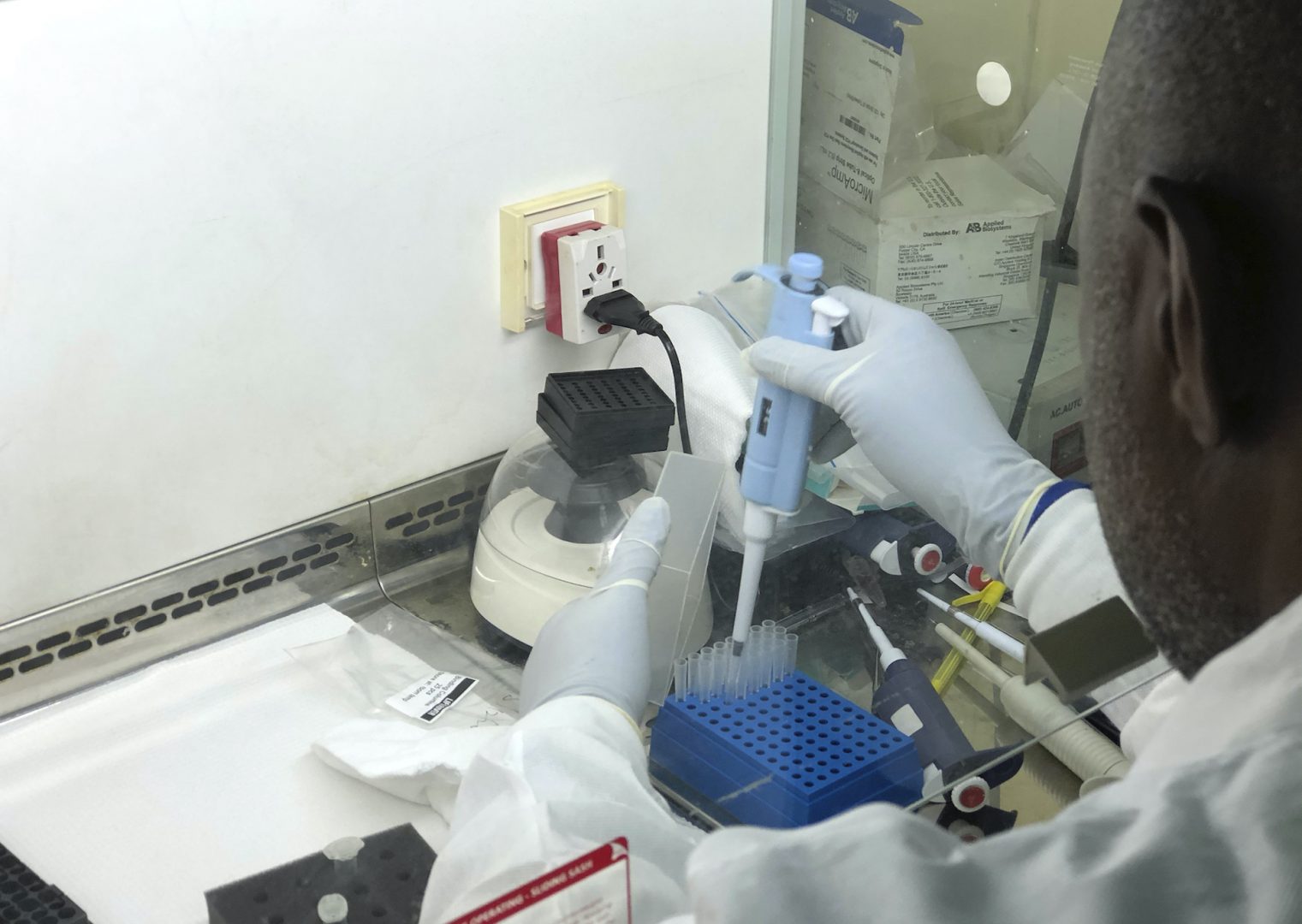 In this photo taken  Friday Dec. 25, 2020, virologist Sunday Omilabu is seen conducting research at the Lagos University College of Medicine and Teaching Hospital.