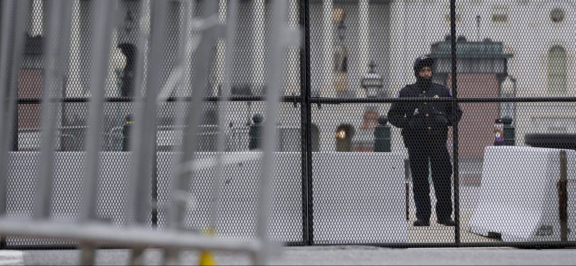 A member of the U.S. Capitol Police stands behind security fencing outside the Capitol Building in Washington, Friday, Jan. 8, 2021, in response to supporters of President Donald Trump who stormed the U.S. Capitol.