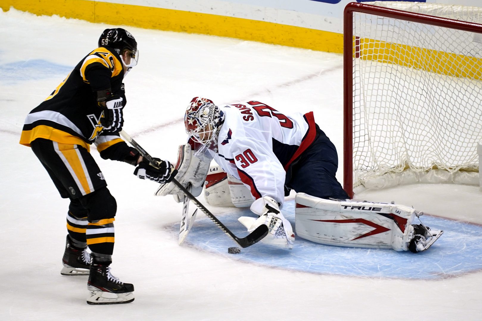 Pittsburgh Penguins' Jake Guentzel, left, puts a shot under the glove hand of Washington Capitals goaltender Ilya Samsonov (30) for a goal during a shootout in an NHL hockey game in Pittsburgh, Sunday, Jan. 17, 2021. 