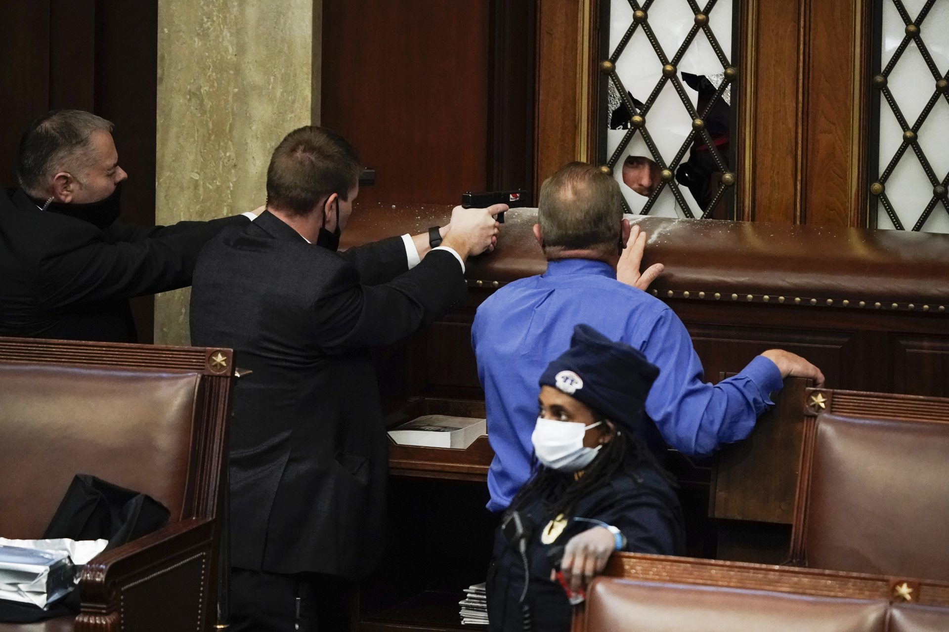 Police with guns drawn watch as protesters try to break into the House Chamber at the U.S. Capitol on Wednesday, Jan. 6, 2021, in Washington.