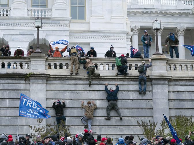 Supporters of President Donald Trump climb the west wall of the the U.S. Capitol on Wednesday, Jan. 6, 2021, in Washington.