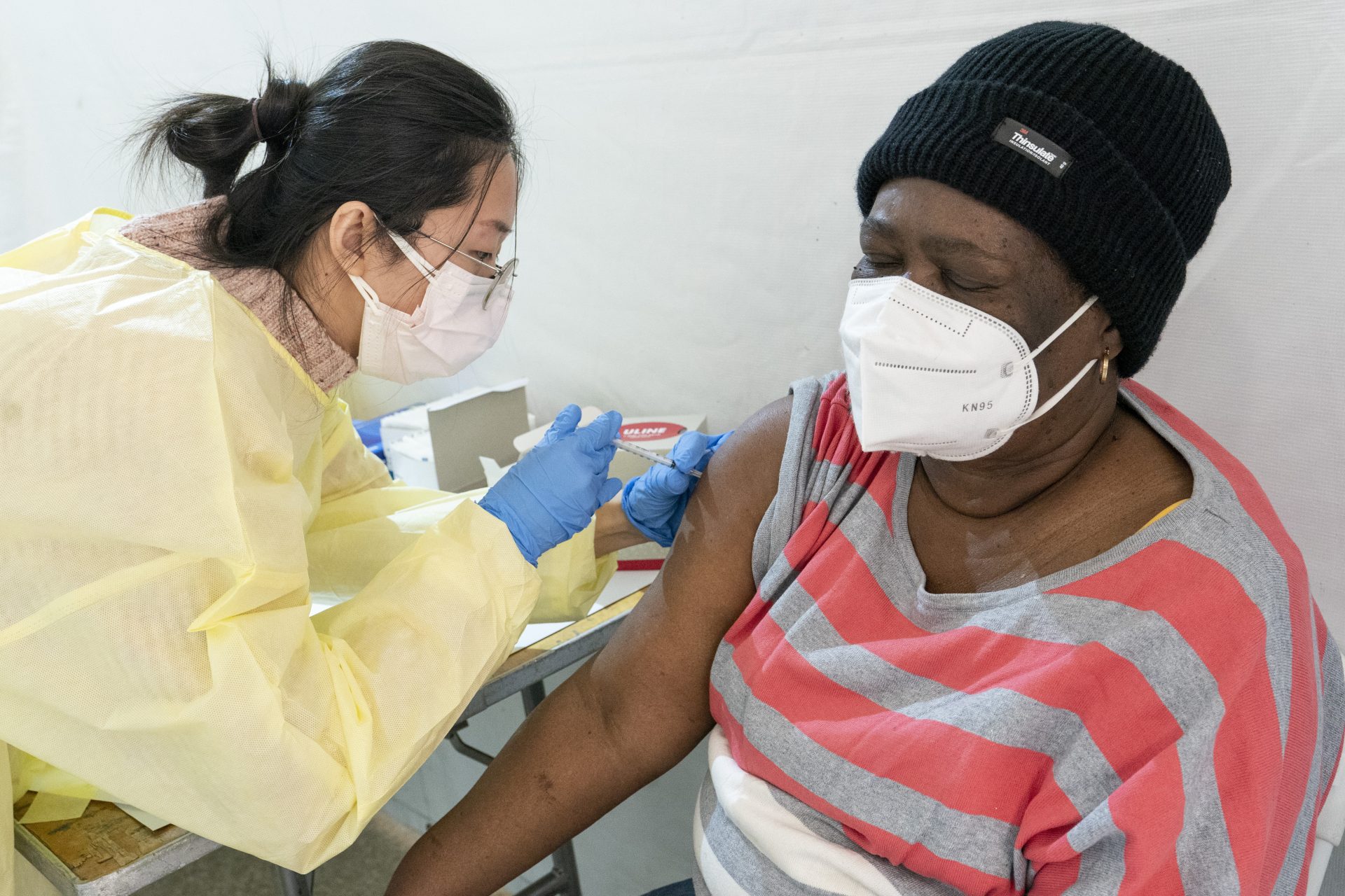 Registered Nurse Shyun Lin, left, administers Alda Maxis, 70, the first dose of the COVID-19 vaccine at a pop-up vaccination site in the William Reid Apartments in Brooklyn, N.Y., on Jan. 23.