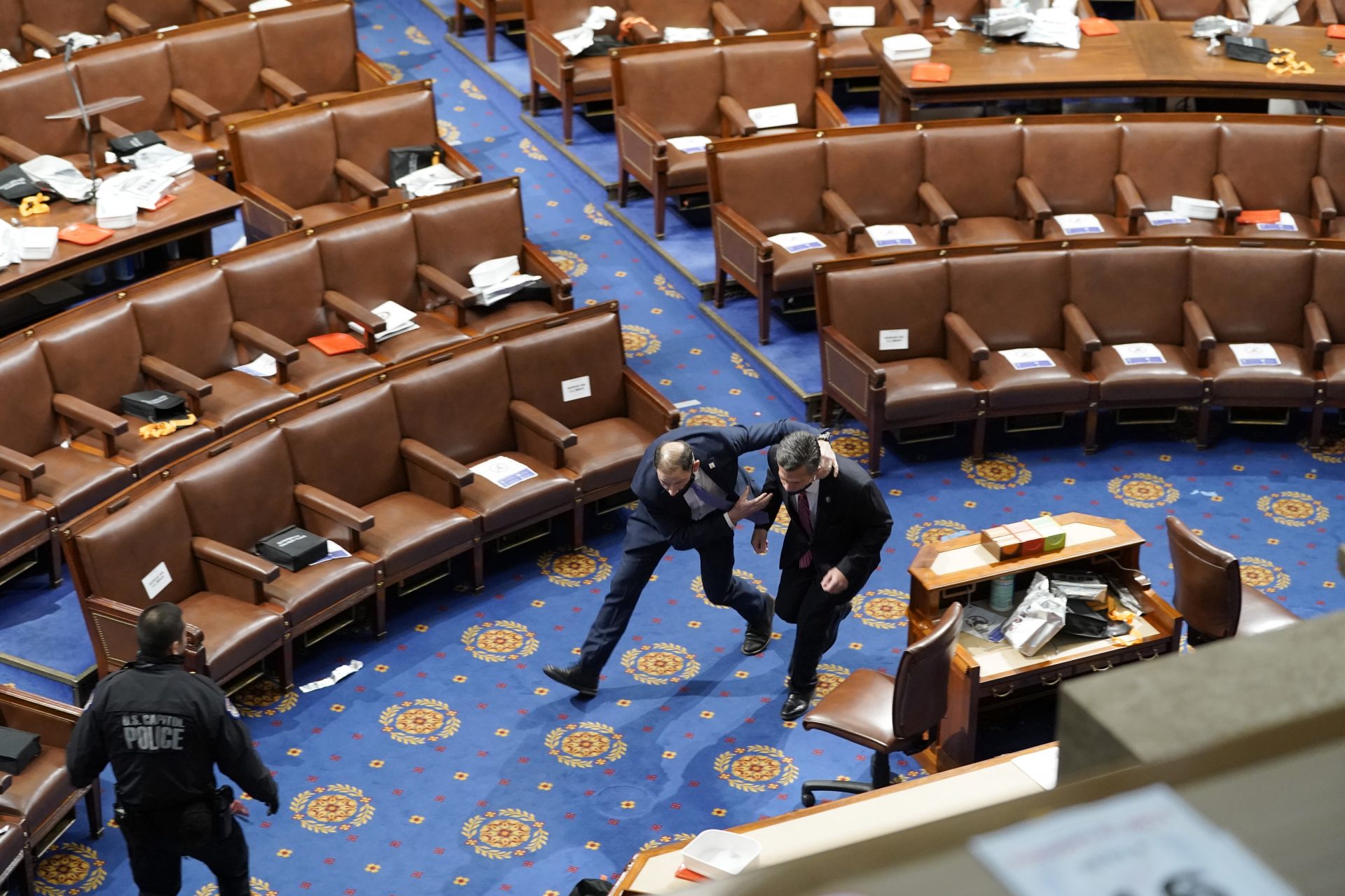 Members of congress run for cover as protesters try to enter the House Chamber during a joint session of Congress on January 06, 2021 in Washington, DC. Congress held a joint session today to ratify President-elect Joe Biden's 306-232 Electoral College win over President Donald Trump. A group of Republican senators said they would reject the Electoral College votes of several states unless Congress appointed a commission to audit the election results.