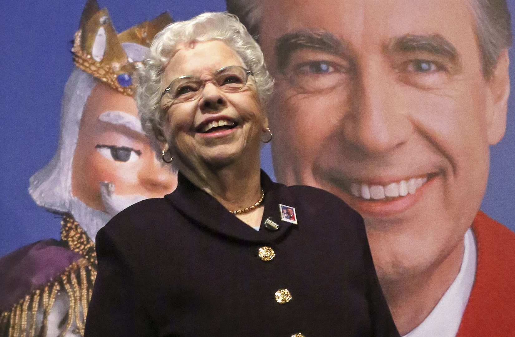Joanne Rogers stands in front of a giant Mister Rogers Forever Stamp following the first-day-of-issue dedication in Pittsburgh on March 23, 2018. Rogers, the widow of Fred Rogers, the gentle TV host who entertained and educated generations of preschoolers on “Mister Rogers’ Neighborhood,” has died. She was 92. 
