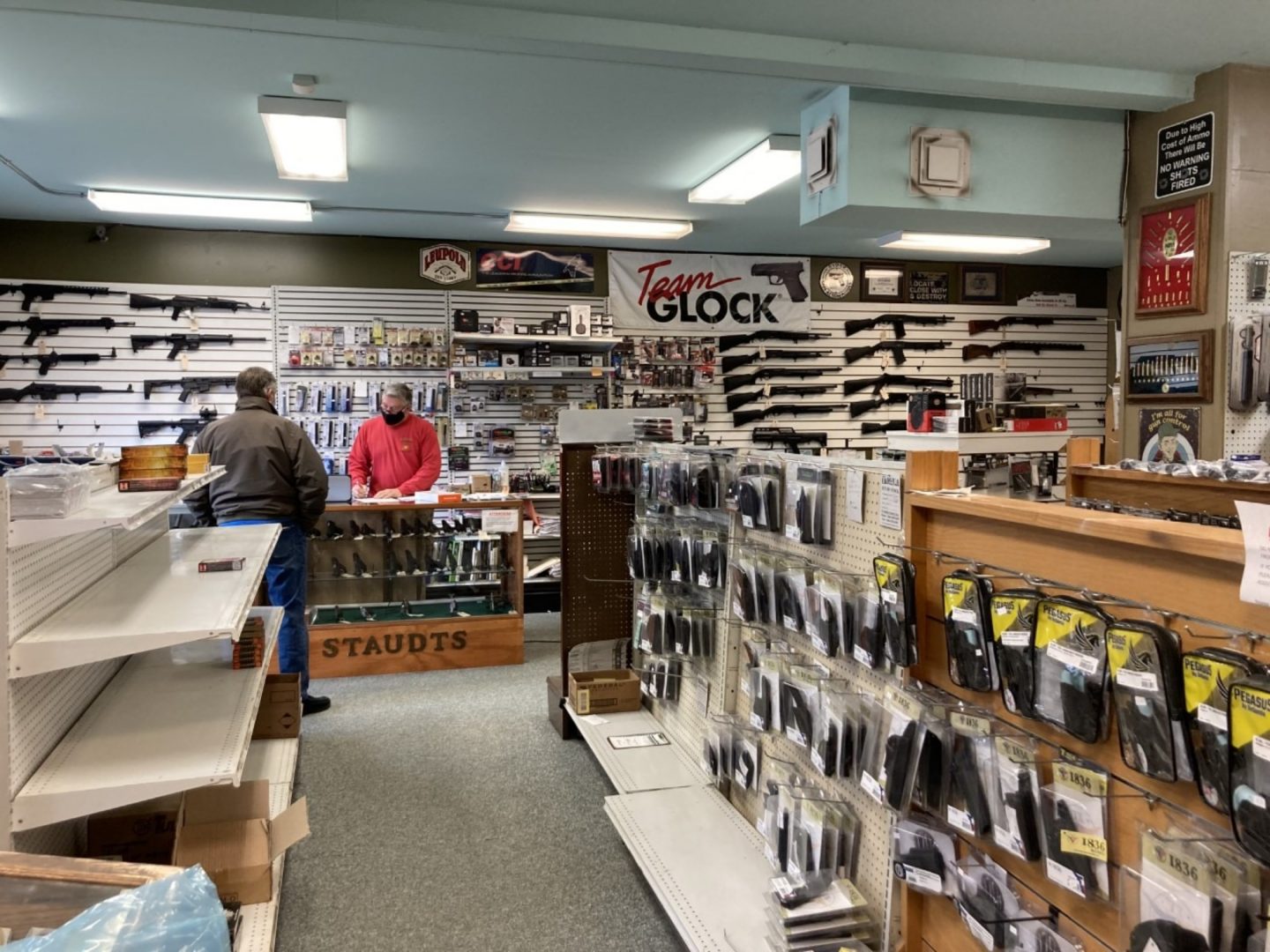 A store employee of Staudts Gun Shop in Harrisburg helps a customer on Jan. 13, 2021.