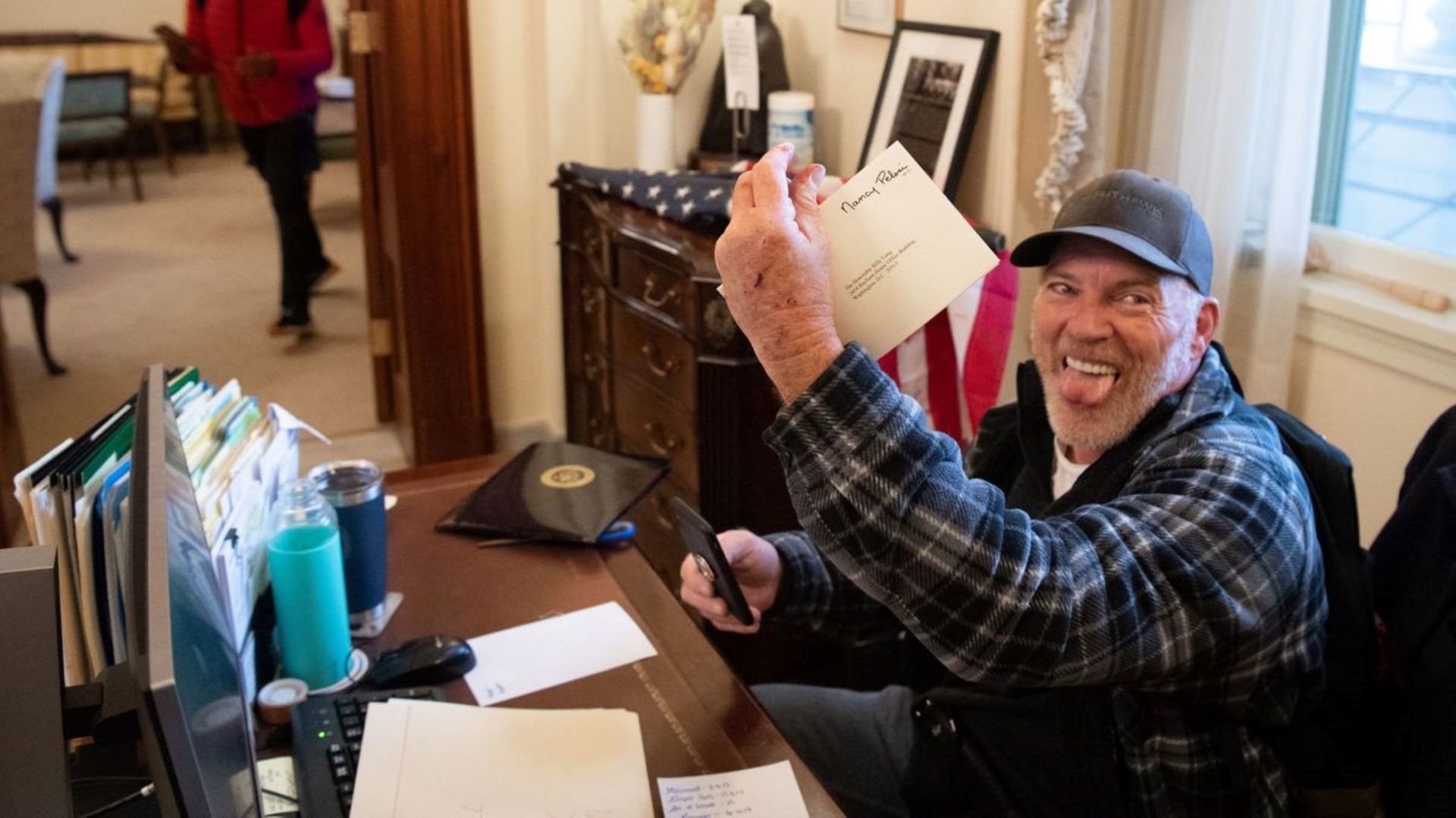 Richard Barnett, a supporter of President Trump, holds a piece of mail as he sits inside the office of Speaker of the House Nancy Pelosi after protesters breached the U.S. Capitol in Washington, D.C., on Jan. 6.