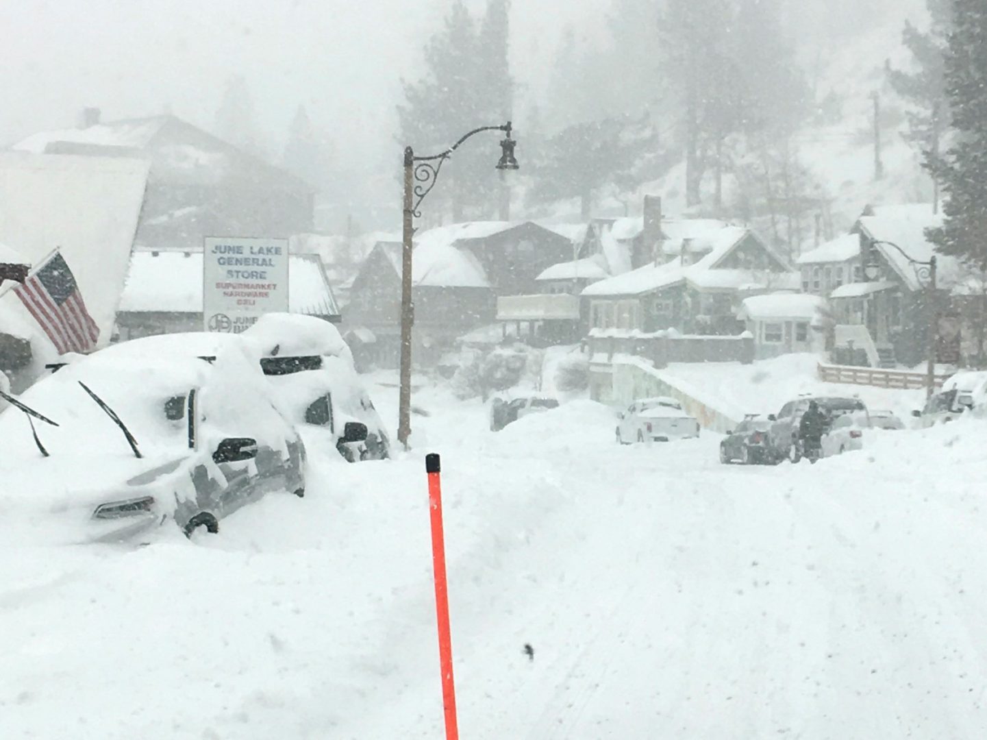 In this photo provided by Caltrans District 9, heavy snowfall blankets cars at June Lake, in Mono County, Calif., on Wednesday. The same storm that brought snow and heavy rain to the state is moving through the Midwest, with 5 to 9 inches of snowfall predicted in some regions by Sunday.