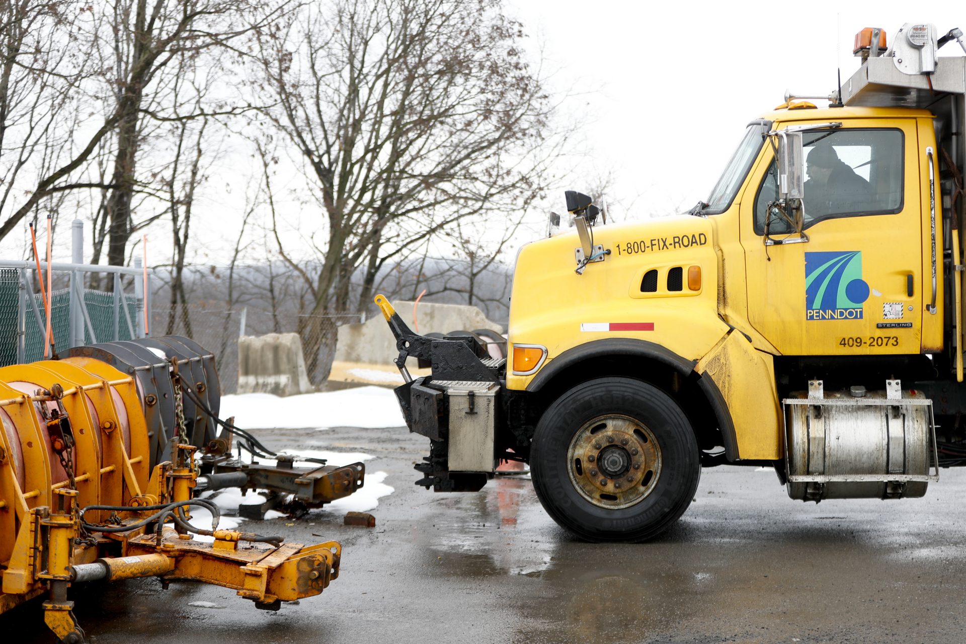 A Pennsylvania Department of Transportation road treatment truck pulls in to attach a plow at a storage facility in Franklin Park, Pa. on Friday, Jan. 18, 2019.