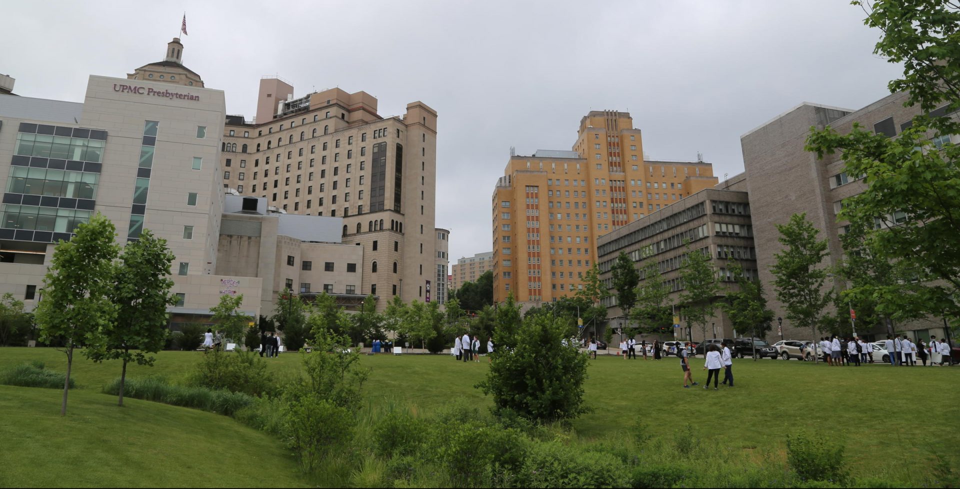Health care workers socialize on the lawn outside UPMC Presbyterian Hospital in Pittsburgh.