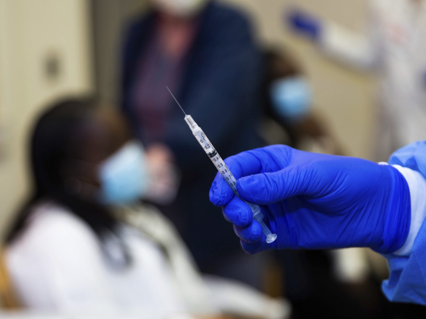 A doctor prepares to administer a vaccine injection to Claudia Scott-Mighty, a patient care director at NewYork-Presbyterian Lawrence Hospital on Friday, Jan. 8, 2021, in Bronxville, N.Y.