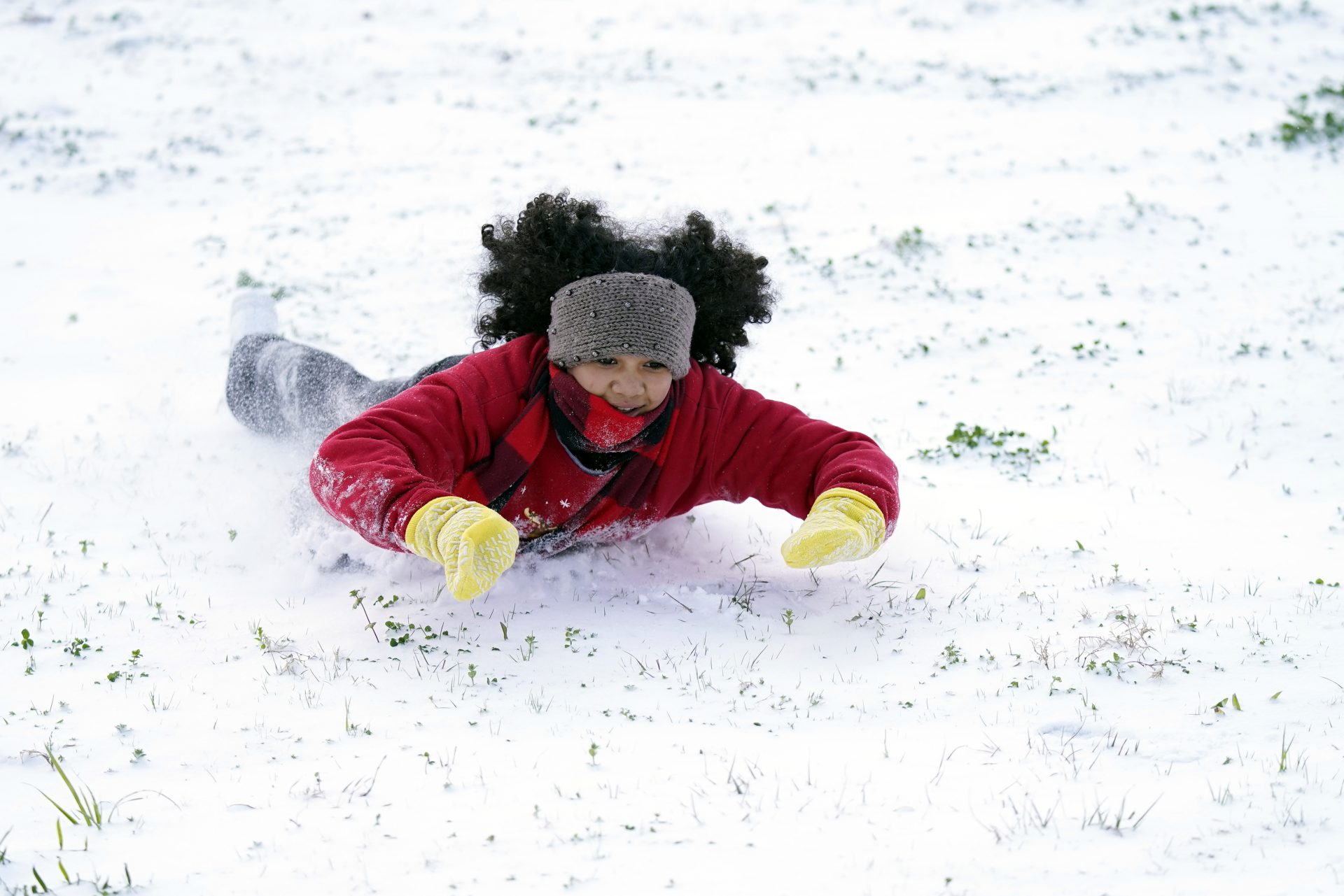 Alyssa Remi, 12, slides down a snow covered hill Monday, Feb. 15, 2021, in Houston.A winter storm dropping snow and ice sent temperatures plunging across the southern Plains, prompting a power emergency in Texas a day after conditions canceled flights and impacted traffic across large swaths of the U.S.