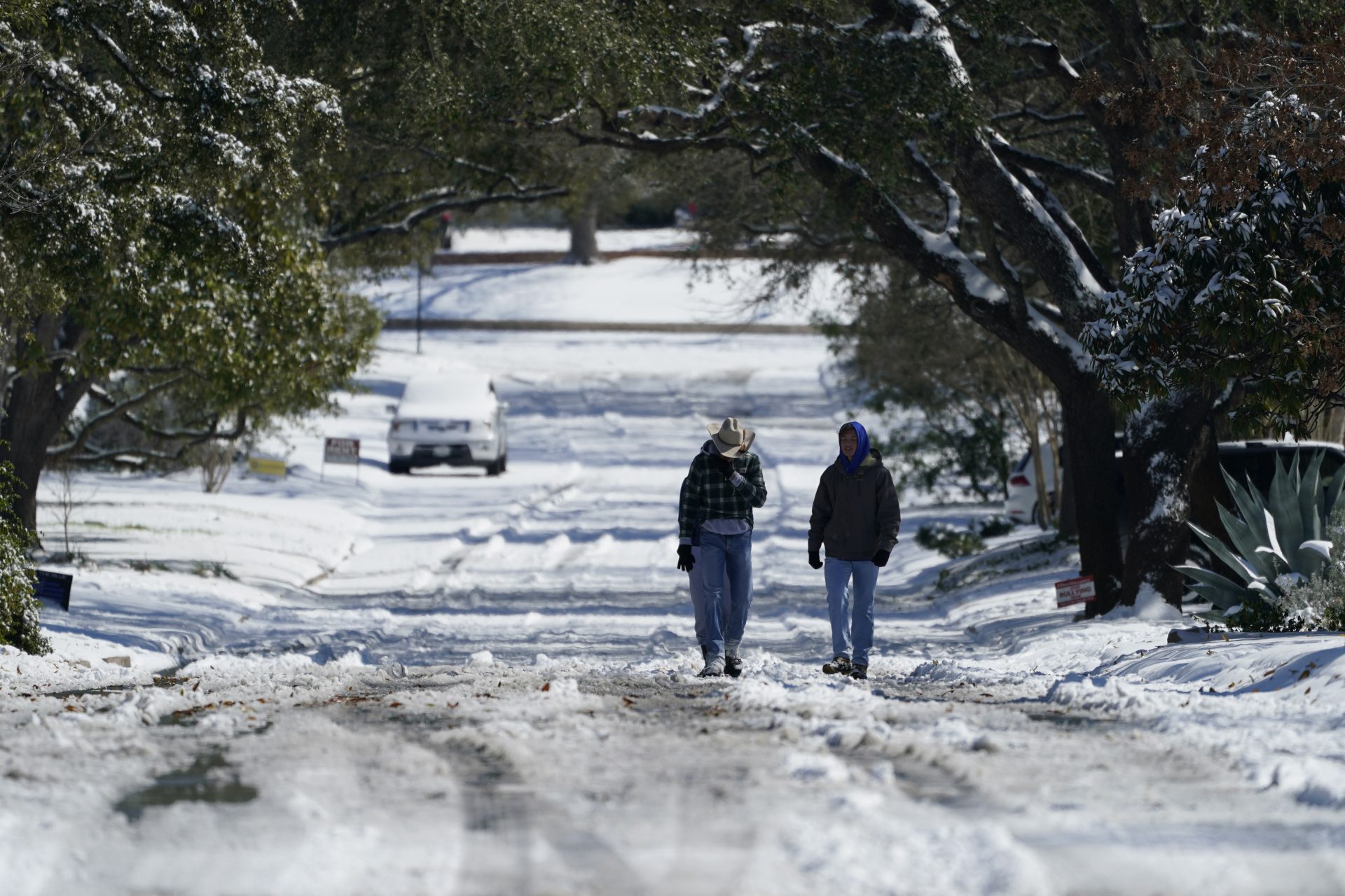 Residents walk through snow, Monday, Feb. 15, 2021, in San Antonio. San Antonio received 3-5 inches of snow over night. A winter storm dropping snow and ice also sent temperatures plunging across the southern Plains, prompting a power emergency in Texas a day after conditions canceled flights and impacted traffic across large swaths of the U.S.