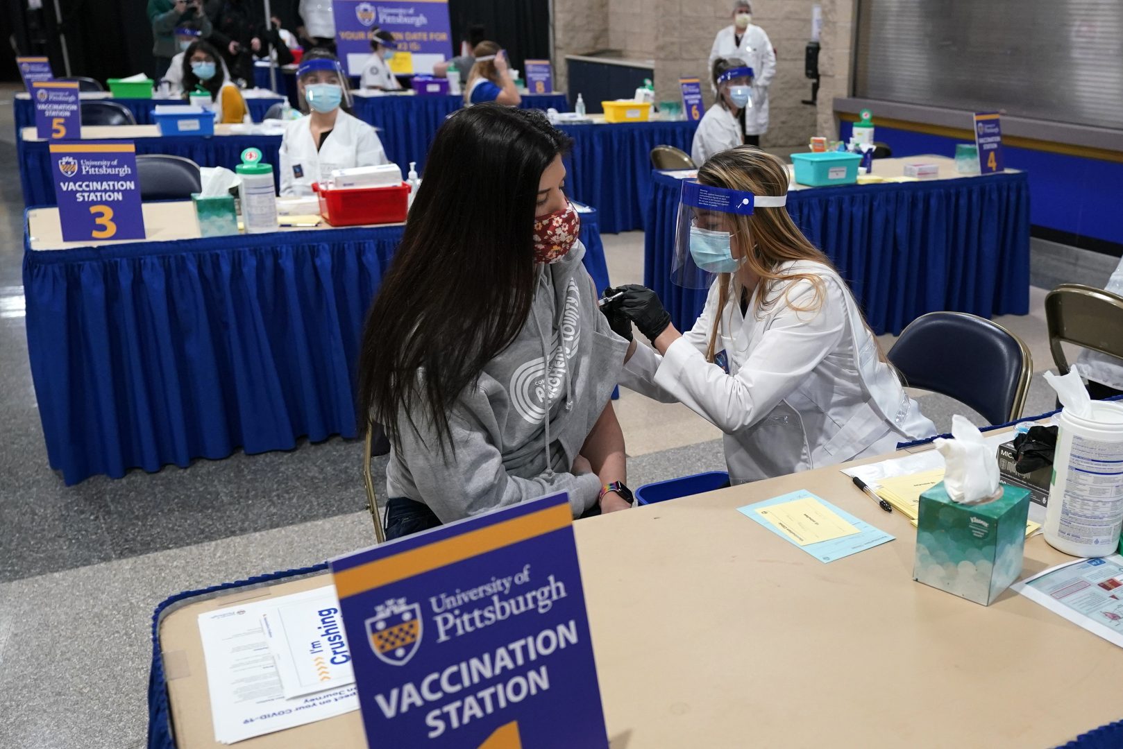 Tiffany Husak, left, a nursing student at the Community College of Allegheny County, receives her first dose of the Moderna COVID-19 Vaccine, during a vaccination clinic hosted by the University of Pittsburgh and the Allegheny County Health Department at the Petersen Events Center, in Pittsburgh, Thursday, Jan. 28, 2021. The clinic, staffed by Pitt faculty and students from Pharmacy, Nursing, Medicine, and Health and Rehabilitation Sciences, will vaccinate some 800 personnel, over two days, who are work in healthcare roles, including students from Chatham College, Community College of Allegheny County, Duquesne University, LaRoche University, Pittsburgh Technical College and Pitt who work with patients. (AP Photo/Gene J. Puskar)