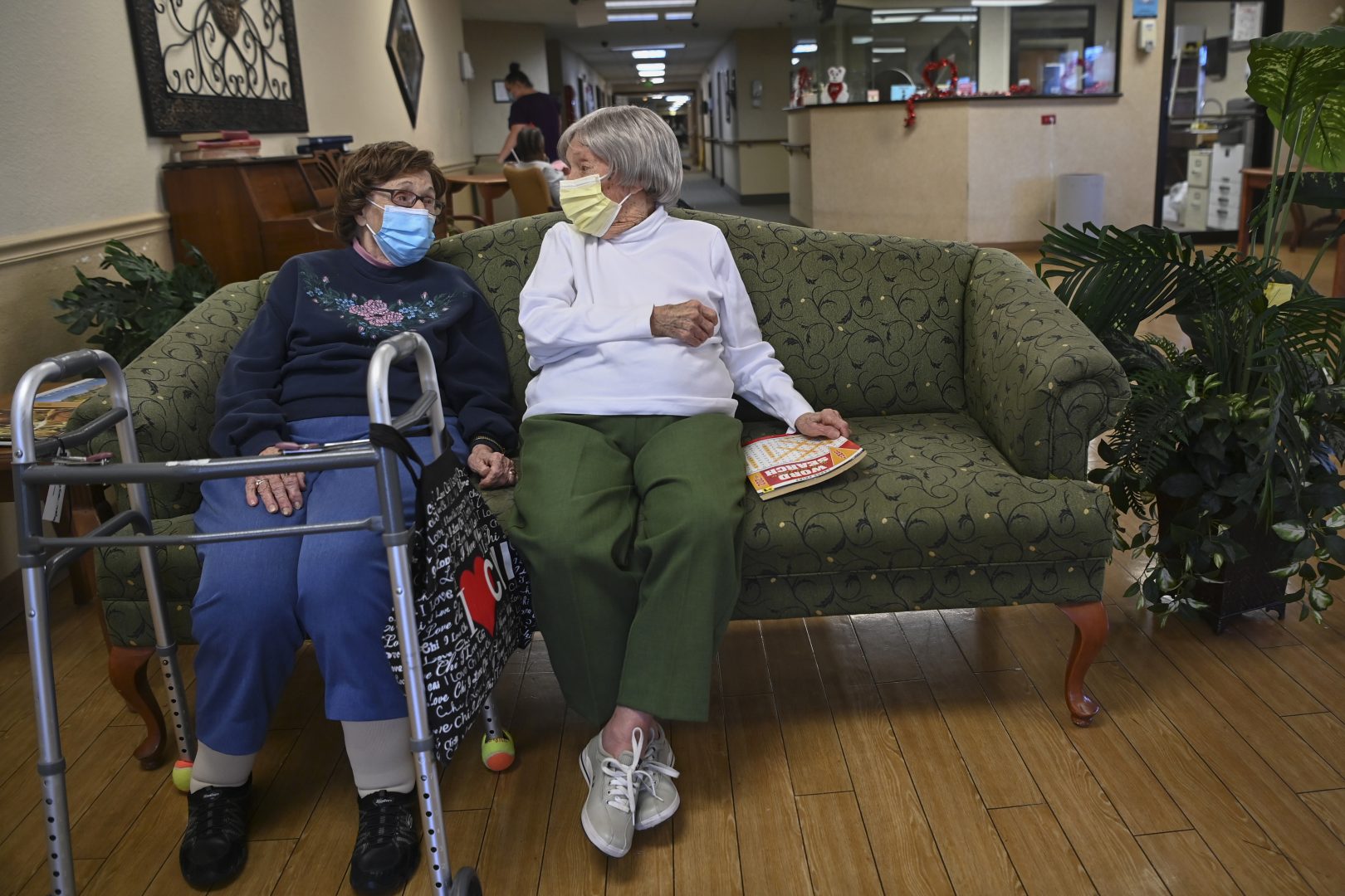 Carmela Sileo, left, and Susan McEachern sit next to each other and talk in the dayroom Wednesday, Feb. 3, 2021, at Arbor Springs Health and Rehabilitation Center in Opelika, Ala. 