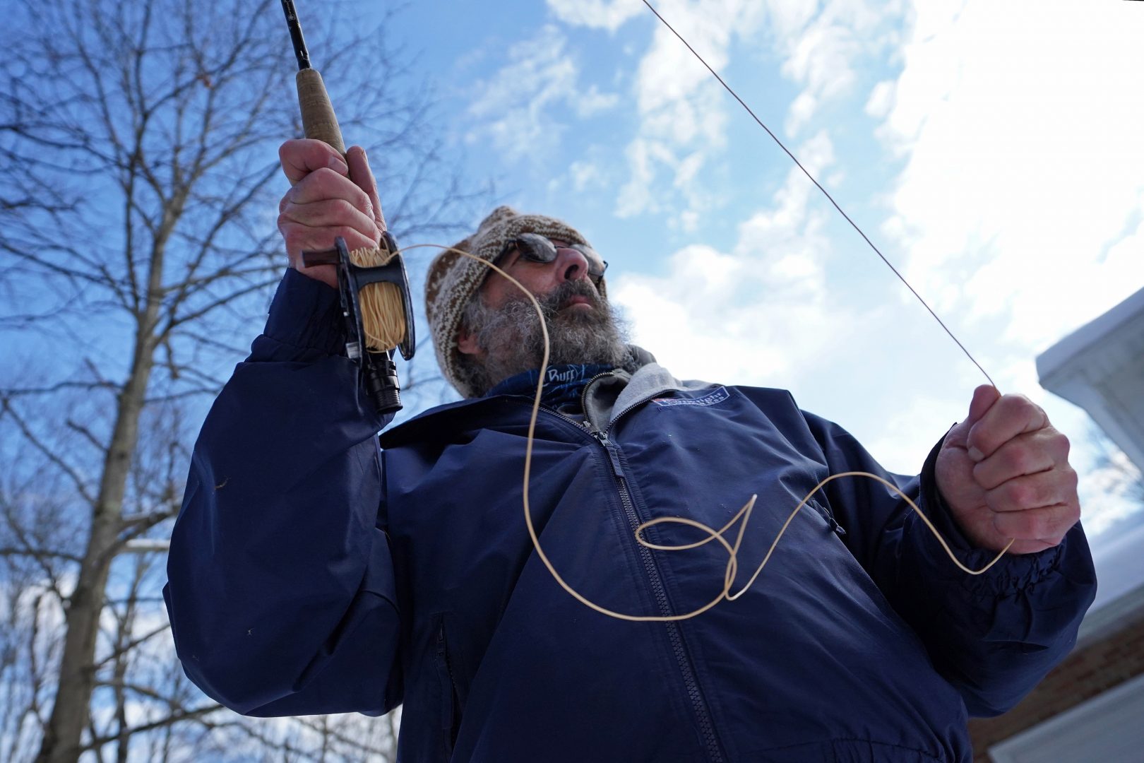 Steve Schwartz demonstrates fly fishing technique in front of his home in Equinunk, Pennsylvania. (Matt Smith/WHYY)