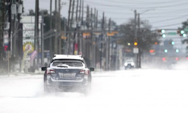 Vehicles drive on snow and sleet covered roads Monday, Feb. 15, 2021, in Spring, Texas. A winter storm dropping snow and ice sent temperatures plunging across the southern Plains, prompting a power emergency in Texas a day after conditions canceled flights and impacted traffic across large swaths of the U.S. 