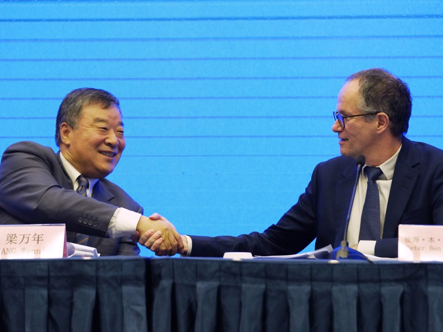 Peter Ben Embarek, of the World Health Organization team, right, shakes hands with his Chinese counterpart Liang Wannian after a WHO-China Joint Study Press Conference held at the end of the WHO mission in Wuhan, China, Tuesday, Feb. 9, 2021. 