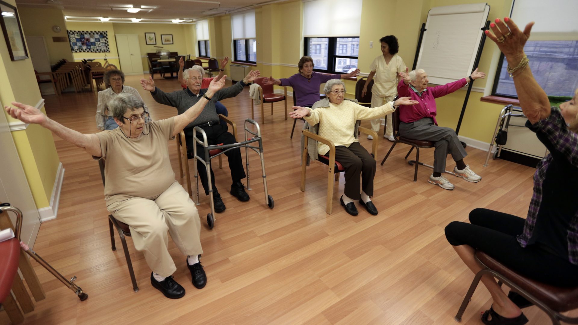In this Oct. 4, 2013 photo, Holocaust survivor, Margie Oppenheimer, 89, left, participates in a yoga class with others at the retirement community called Selfhelp Home, on the North Side of Chicago. One day at the Stutthof concentration camp in Poland, Nazis marched Oppenheimer and others naked into an open field for inspection. Those strong enough to work were directed to the right. Oppenheimer, who was emaciated, was ordered to the left with hundreds of older women. She was placed into new barracks and had the Roman numeral II scrawled on her left forearm. Death seemed inevitable. "I'm thinking this is the last time I will see the sun," she recalls.
