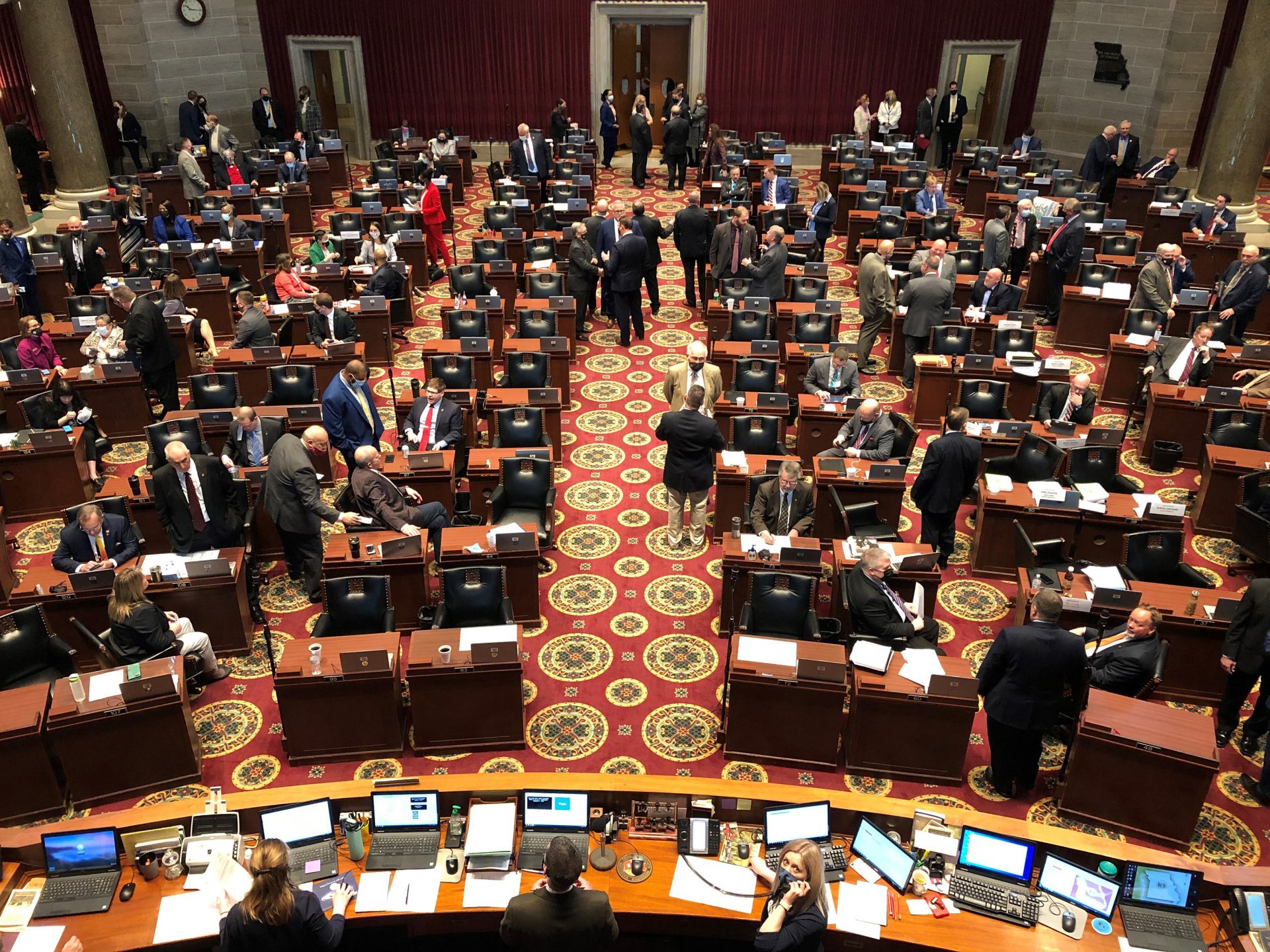 Members of the Missouri House gather in the chamber before the beginning of session on Wednesday, Feb. 3, 2021, in Jefferson City, Mo. The House chamber has no mask mandate and has not modified its seating during the coronavirus pandemic. The House canceled all work for a full week in January after a COVID-19 outbreak.