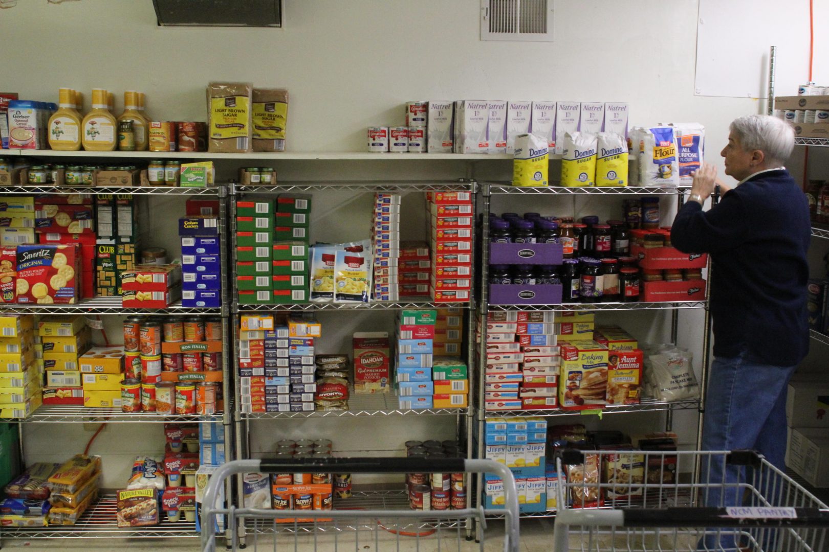 FILE PHOTO: A volunteer stocks shelves at the Northside Food Pantry in Pittsburgh in this 2017 photo.