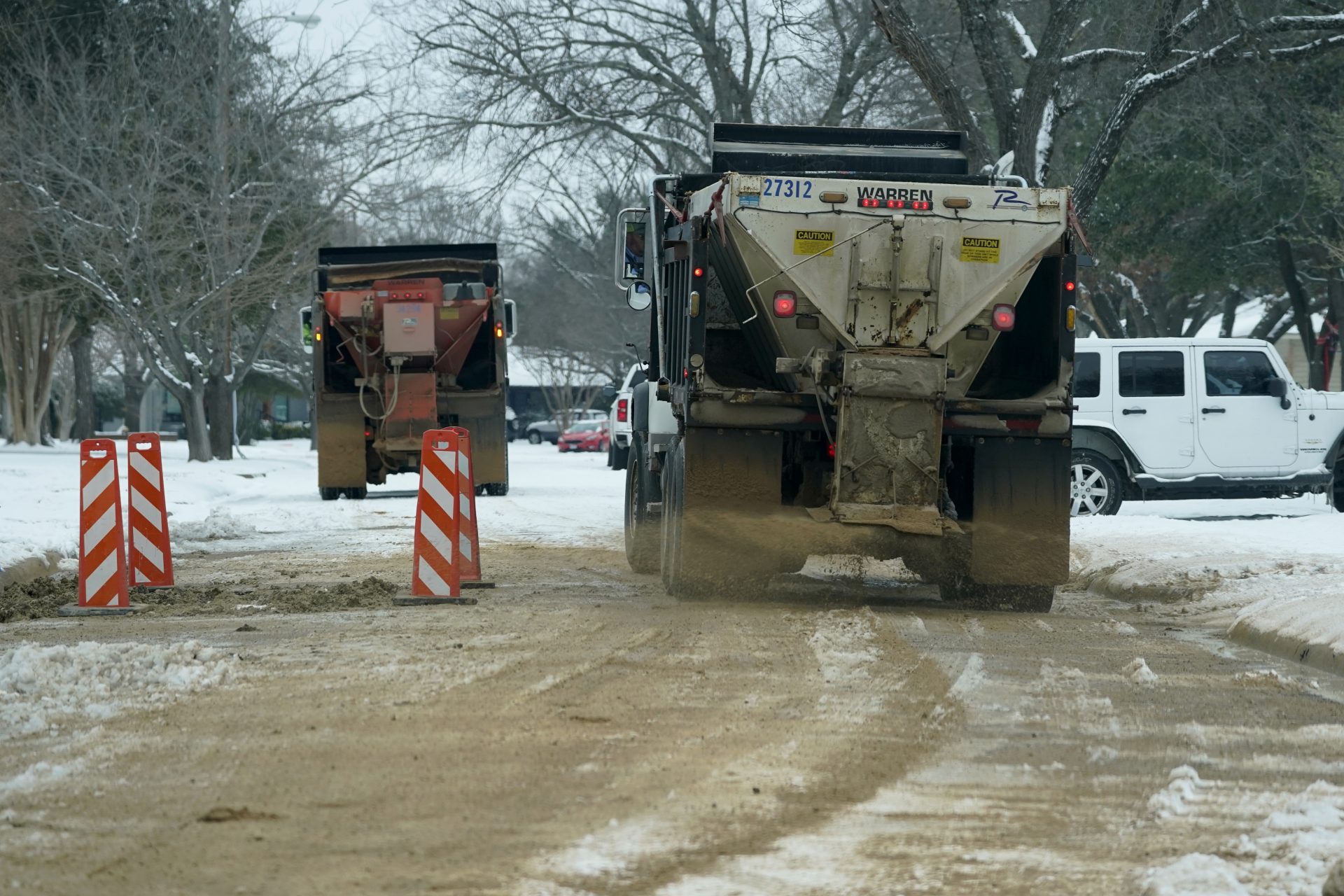 City work crews drop de-icing agent on a residential street in Richardson, Texas, Wednesday, Feb. 17, 2021.