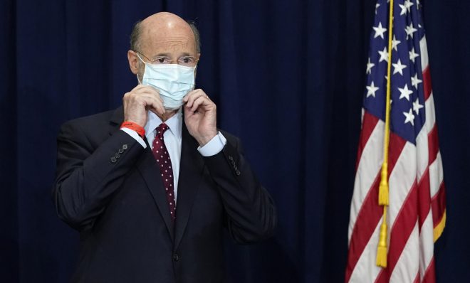 In this Nov. 4, 2020, file photo, Pennsylvania Gov. Tom Wolf adjusts his face mask to protect against COVID-19 during a news conference in Harrisburg, Pa. 