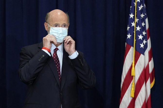 In this Nov. 4, 2020, file photo, Pennsylvania Gov. Tom Wolf adjusts his face mask to protect against COVID-19 during a news conference in Harrisburg, Pa.