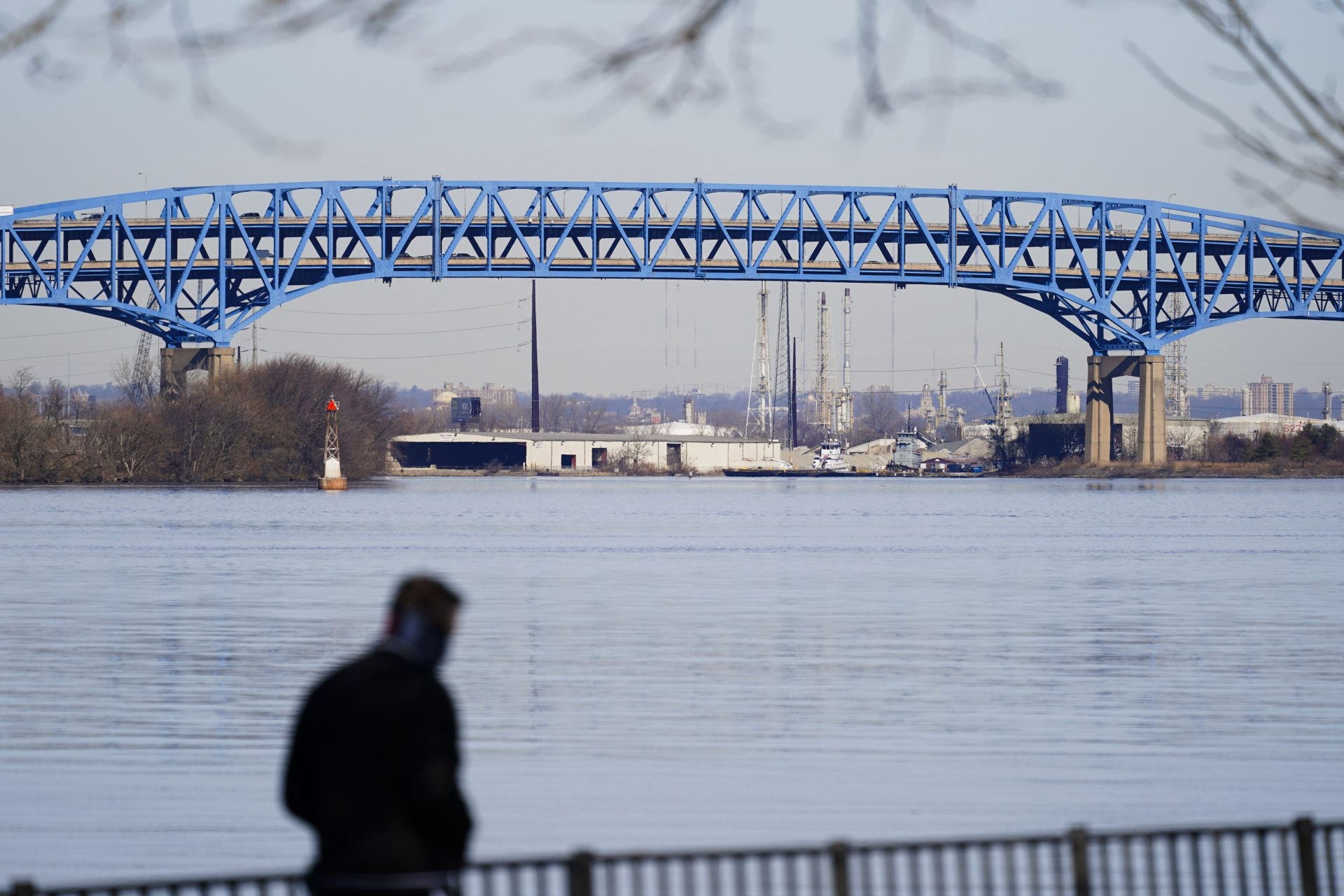 A person walks past the Interstate-95′s mile-long double-decked Girard Point Bridge in Philadelphia, Wednesday, Feb. 24, 2021. PennDOT named several bridges including the Girard Point Bridge that it said it is considering tolling to pay for the reconstruction.